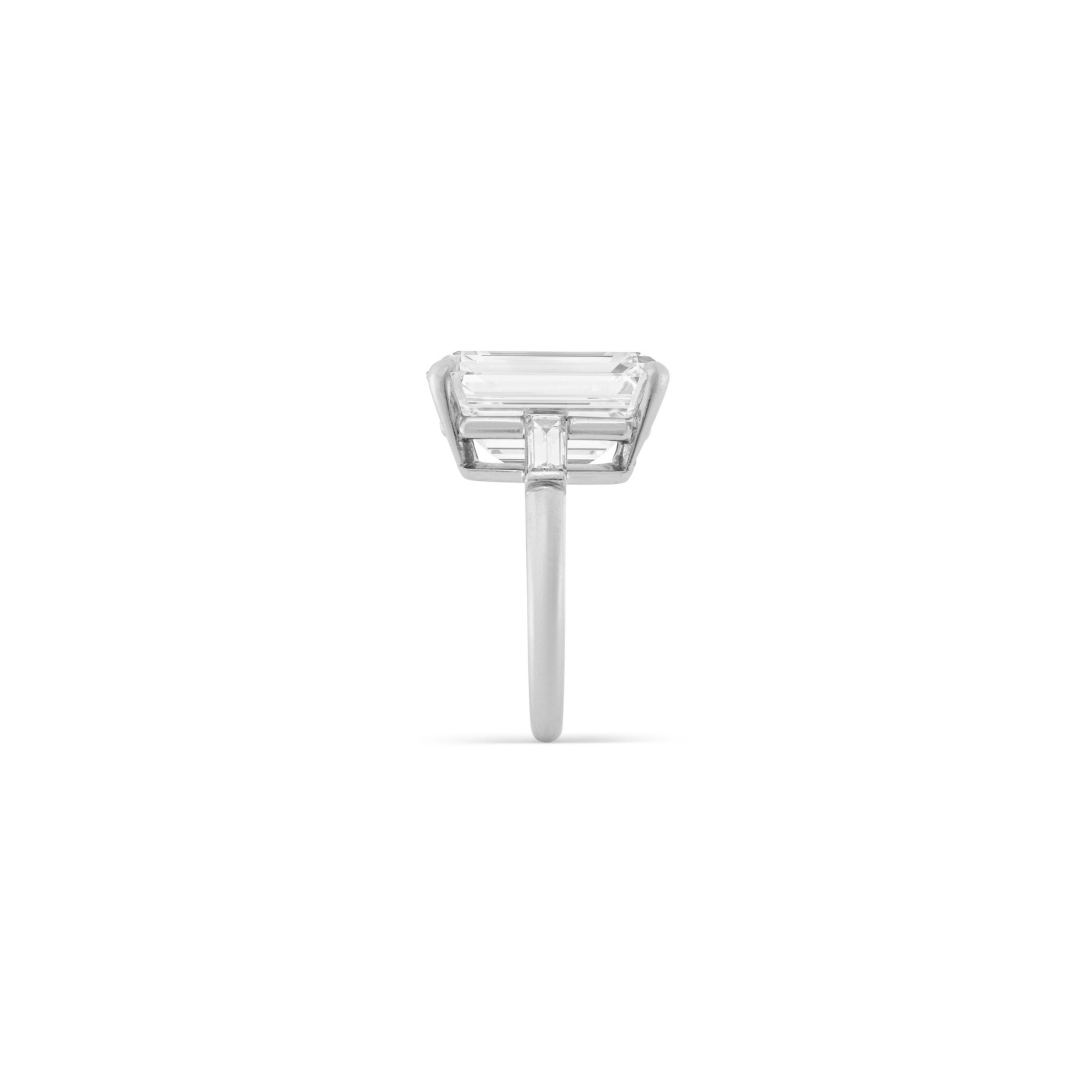 Showcasing a 6 carat emerald-cut diamond of exceptional h color and VS1 clarity (GIA Certified), this elegant engagement ring is crafted in 18K white gold. The center stone’s clean lines and radiant fire are complemented by a pair of tapered