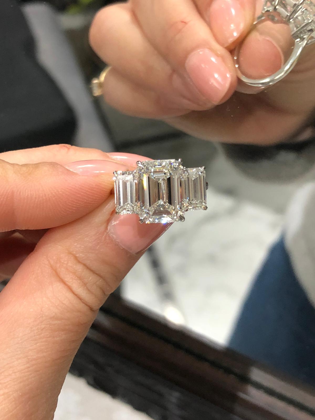 An extraordinary GIA certified three stone 7 carat emerald cut diamond ring.
The main stone is a 5 carat I color si1 Clarity 100% Eye clean stone
