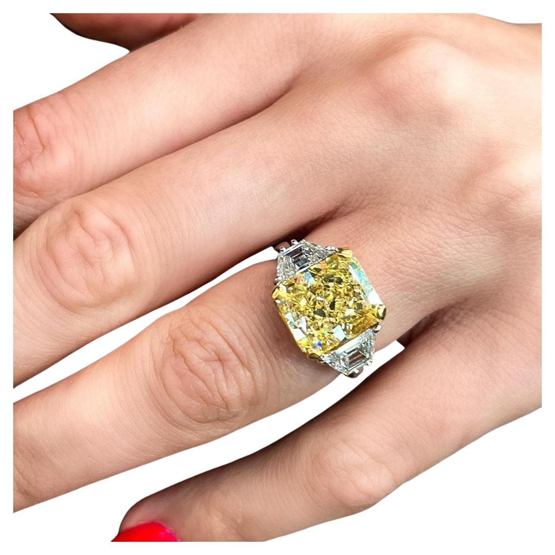 Este extraordinario anillo de compromiso incluye un diamante amarillo fantasía de talla radiante de 5,74 quilates, certificado por el GIA y elegido por su excepcional intensidad de color y claridad superior. 

 Con un grado de claridad VVS1, el