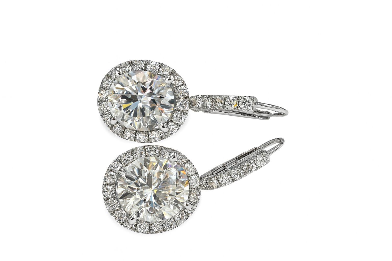 Ein atemberaubendes Paar Diamant-Ohrringe aus Platin, das zeitlose Eleganz und außergewöhnliche Handwerkskunst ausstrahlt. Jeder Ohrring besteht aus einem ovalen Diamanten im Brillantschliff mit einem Gewicht von 3,01 Karat, dessen Merkmale perfekt