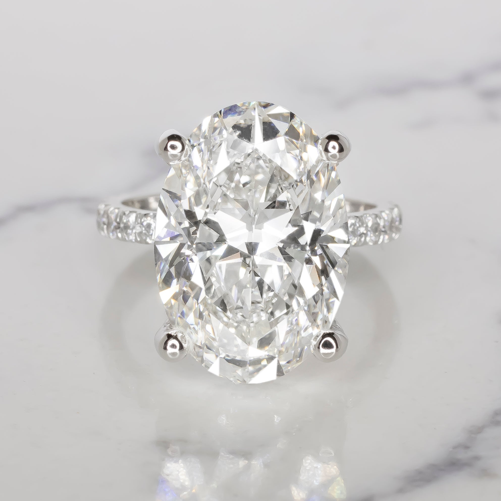 This extraordinary engagement ring features a 6.01 carat oval cut diamond, captivating with its timeless elegance and remarkable brilliance. 

Certified by GIA, the diamond is graded F in color, it is completely colorless, showcasing unparalleled