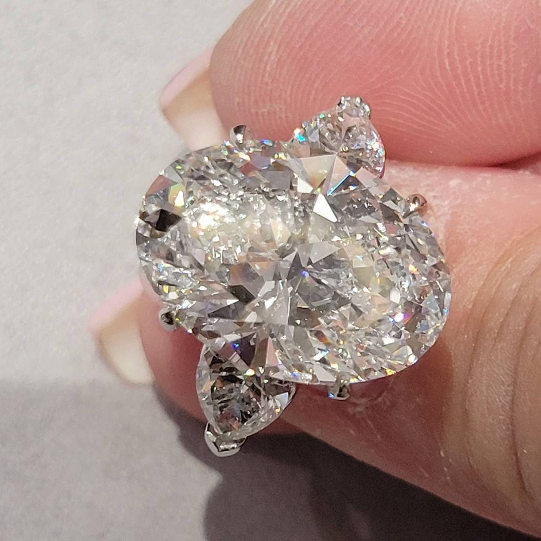 Contemporary GIA Certified 7.01 Carat Oval Cut Diamond Platinum Ring with Pear Cut Diamonds For Sale