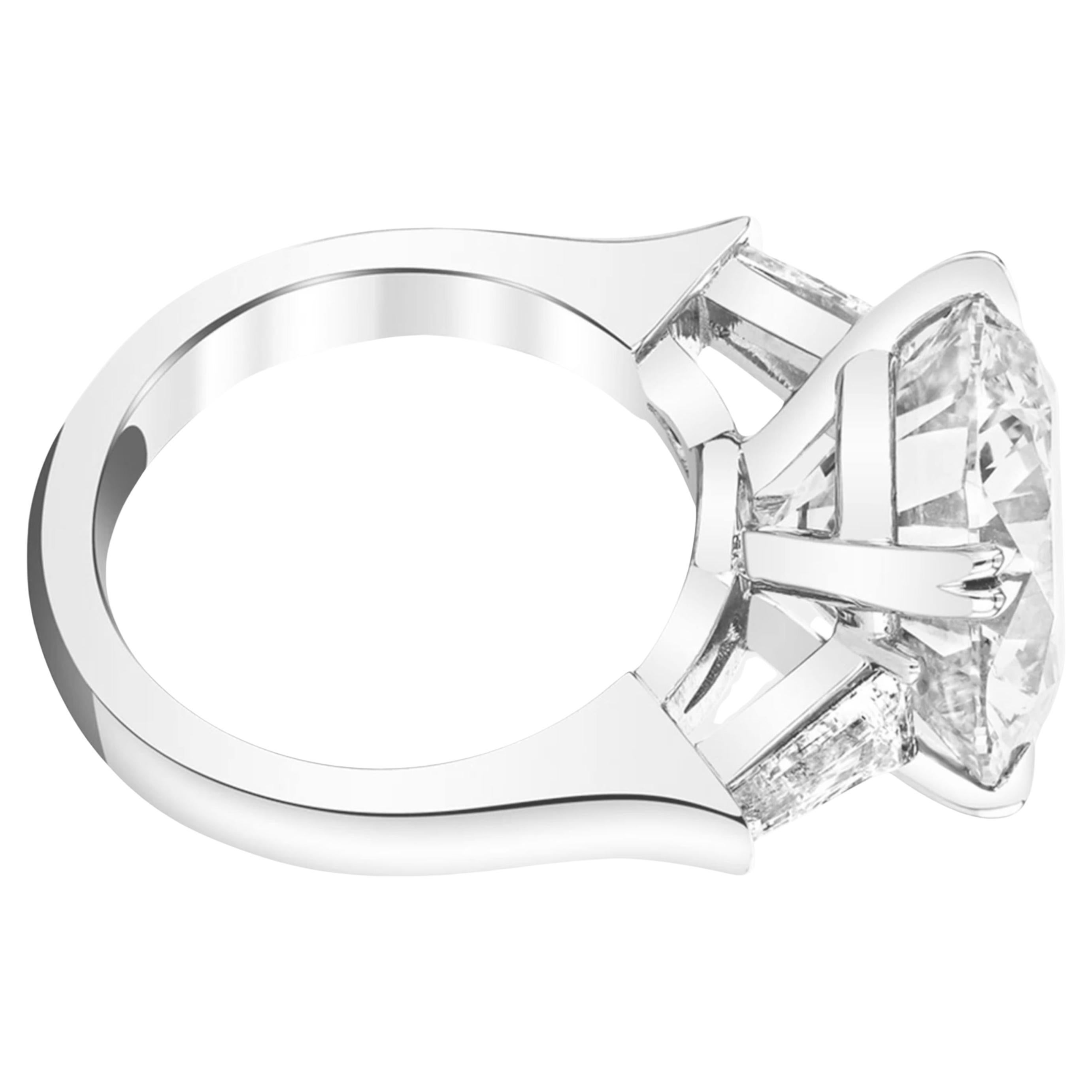 Cette magnifique bague certifiée GIA est ornée d'un magnifique diamant rond brillant de 6,01 carats, serti dans un élégant anneau en or blanc 18 carats. 

Le diamant de couleur E est presque incolore, affichant une chaleur subtile qui ne nuit pas à