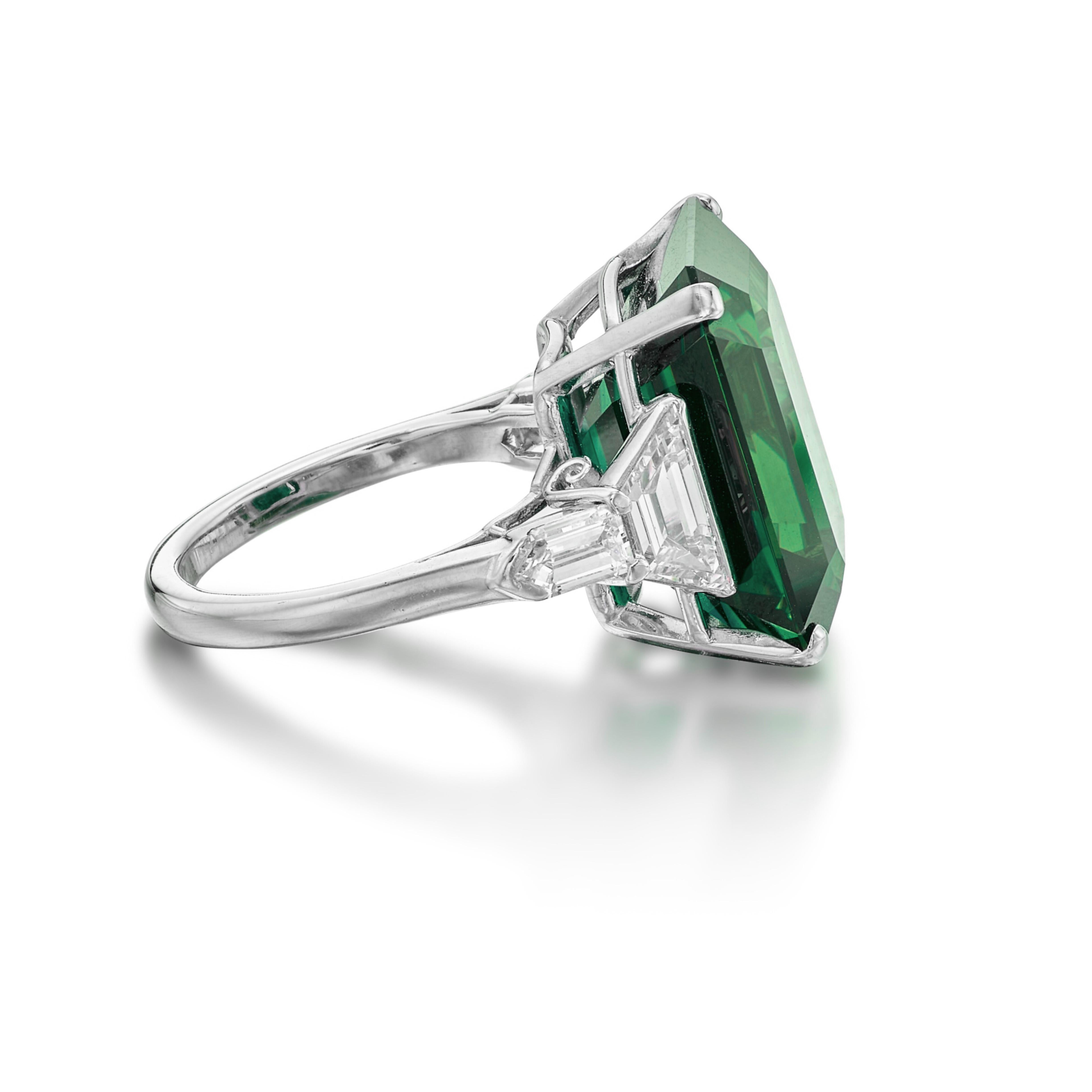 Centering an 6 ct.  emerald, flanked by trapezoid and kite shaped diamonds
Size 6
Platinum
Accompanied by GIA report
