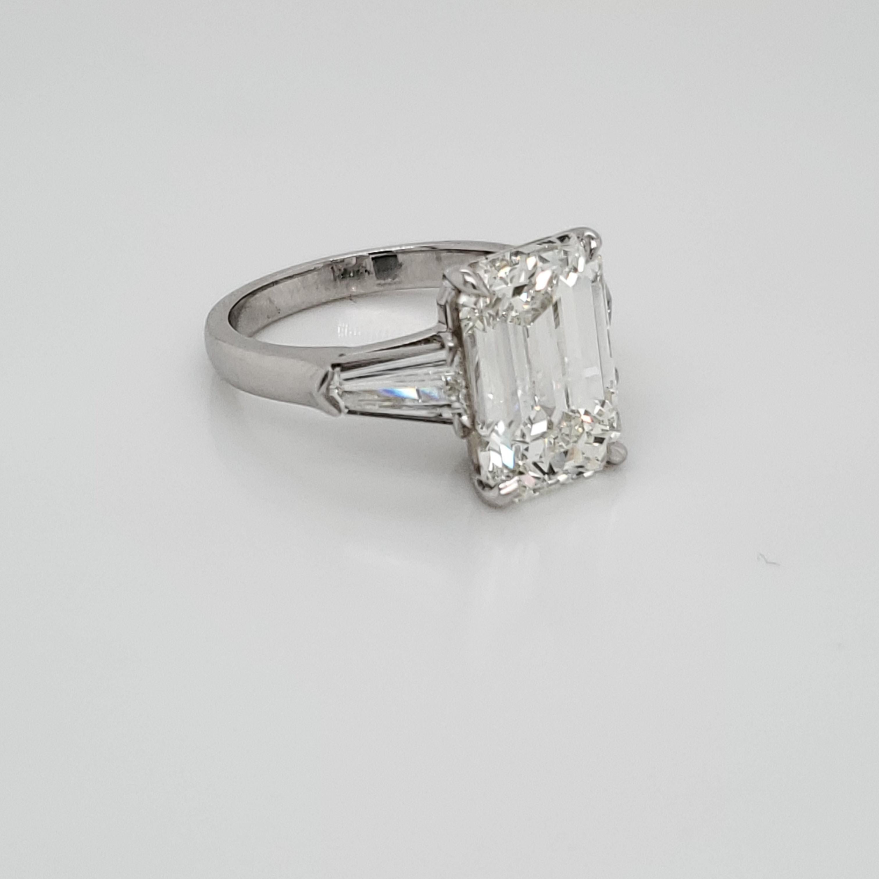 GIA certified Three stone ring. The center stone is a 6.01 GIA K color and SI1 clarity. The 2 bullet side diamonds weigh 0.45 carats each and are of matching color and clarity to the center stone. The ring is made of platinum. 