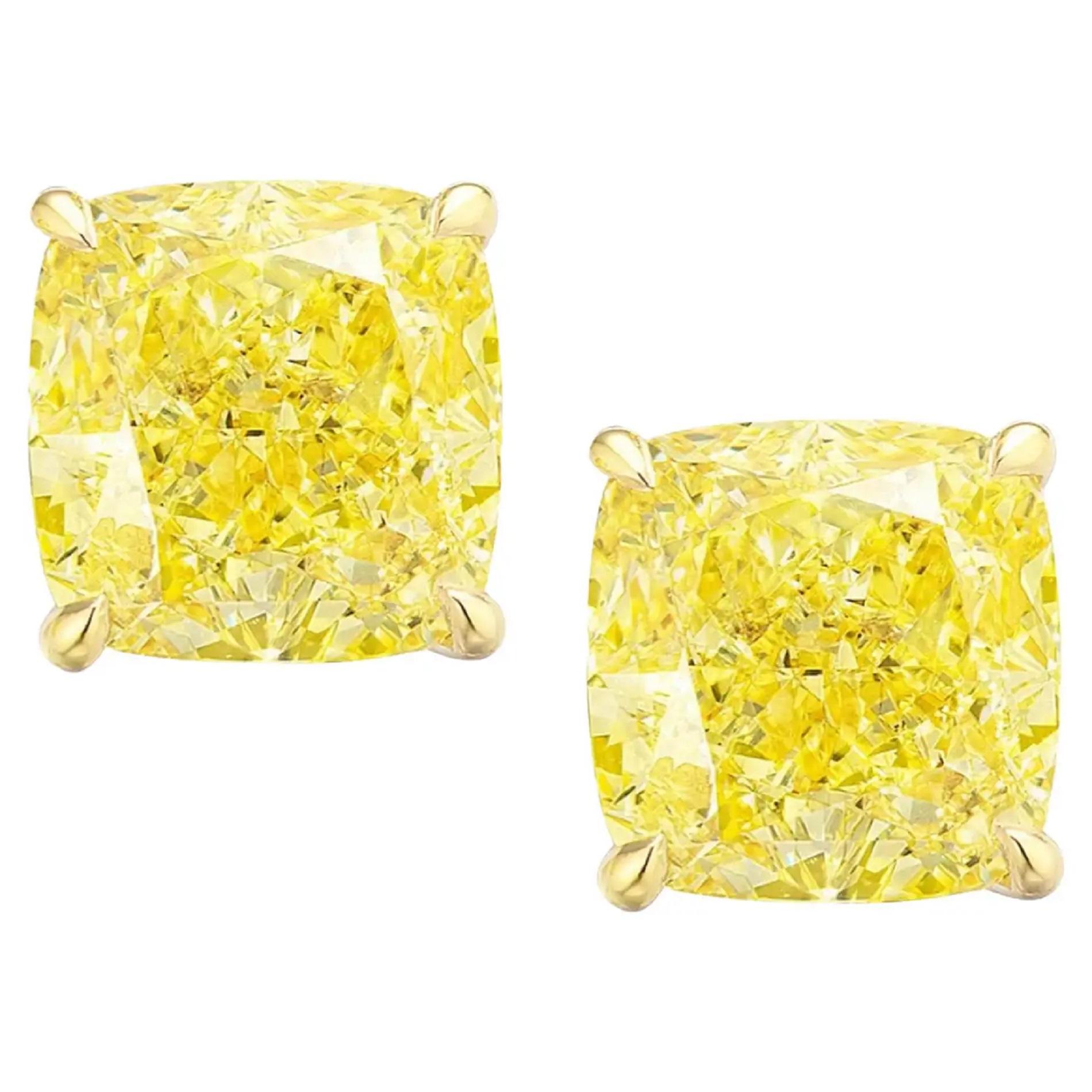 Elevate your elegance with these stunning stud earrings, each adorned with a pair of cushion-cut diamonds, each weighing an impressive 3 carats. The diamonds, boasting a striking Fancy Intense Yellow color, radiate warmth and vibrancy, adding a