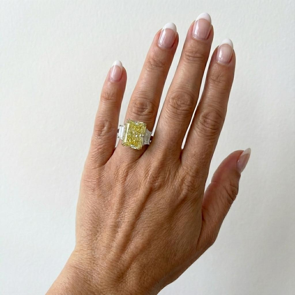 Un notevole diamante Fancy Intense Yellow da 6,01 carati, certificato da GIA, mostra un'elegante forma a brillante rettangolare modificata con distribuzione uniforme del colore e brillantezza eccezionale. Il diamante mostra una tonalità gialla