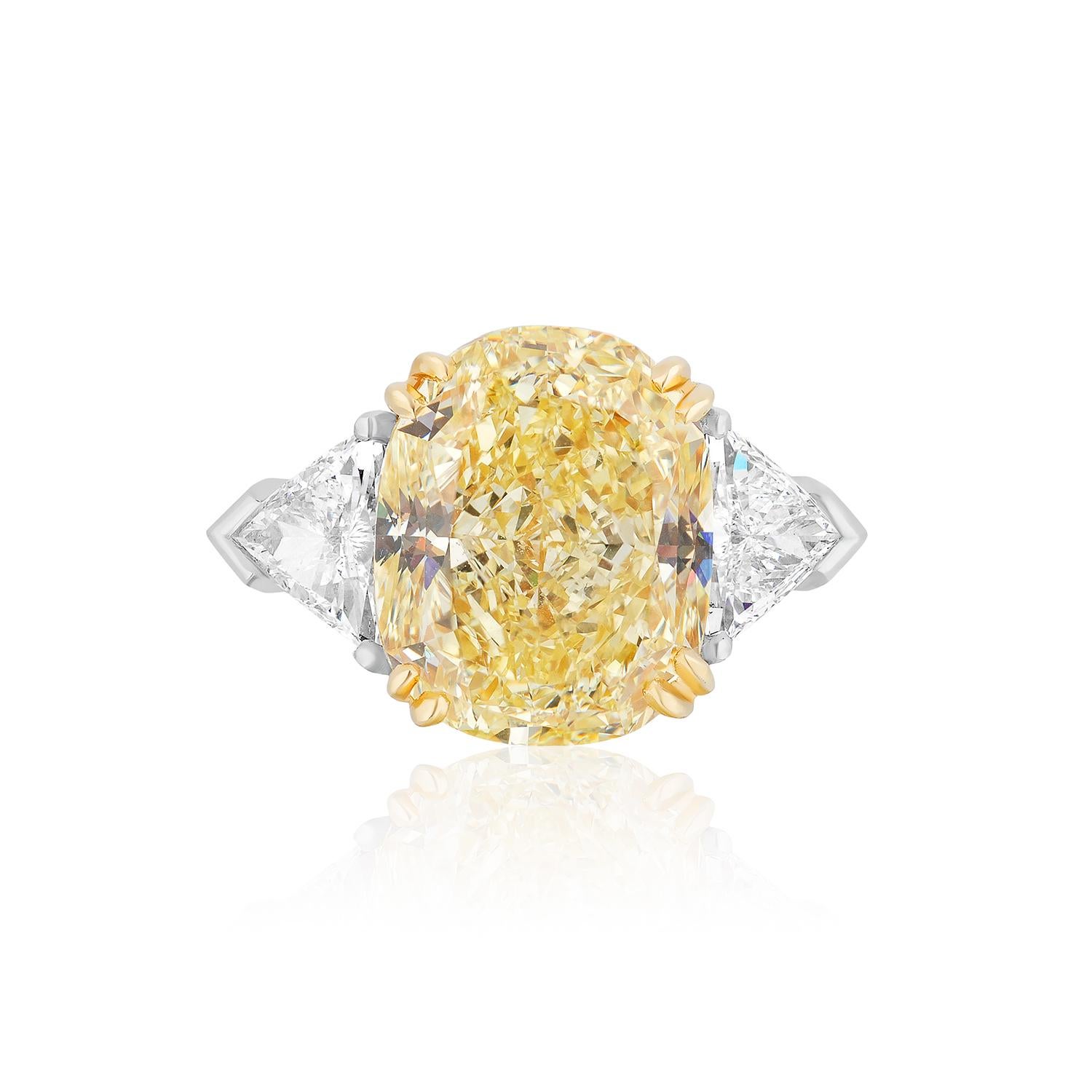 Centered upon a beautiful Fancy Yellow Diamond with a VS1 Clarity. Beautiful and hard to find elongated Cushion flanked by 2 Triangle Diamonds weighing 0.79 Carats.
Set in Platinum and 18 Karat Yellow Gold.