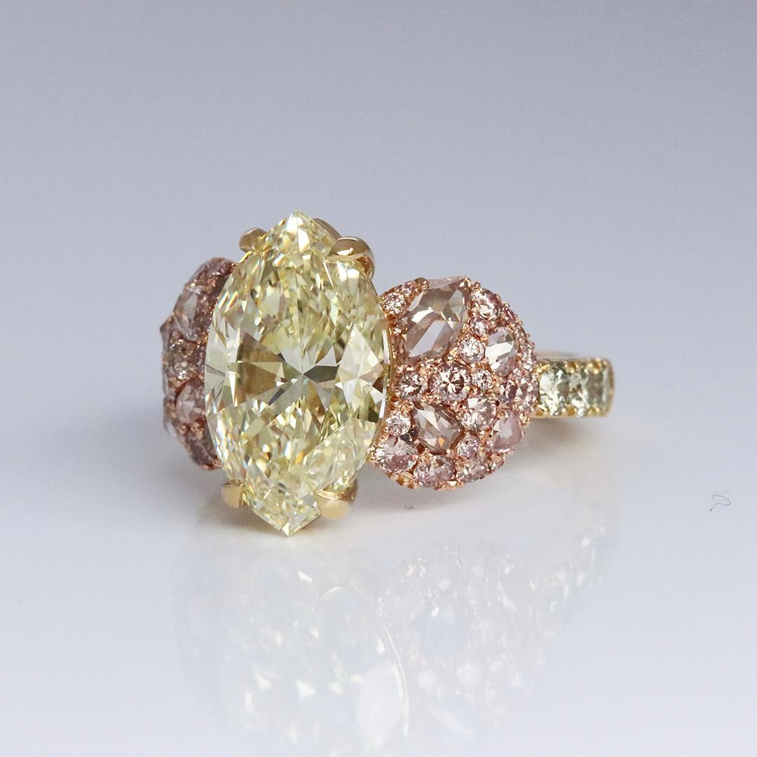 Introducing a one-of-a-kind ring in 18K Yellow & Rose gold with a stunning GIA Certified Fancy Light Yellow 6.02 ct. Marquise shape diamond centerstone. The centerstone is surrounded by a beautiful array of pave set Fancy Pink brilliant-cut