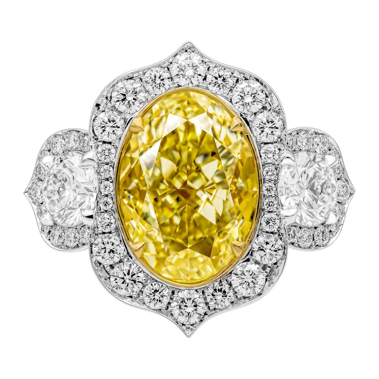 Aladdin Style 3 stone ring 
Crafted in Platinum & 18K Yellow Gold,
Center: 6.02ct Natural Fancy Light Yellow Even VS1 Oval Shape Diamond GIA#5221505250
2 side round stones: 0.73ct & 0.70ct (Totaling 1.43ct) 
Diamond cathedral shank and fully