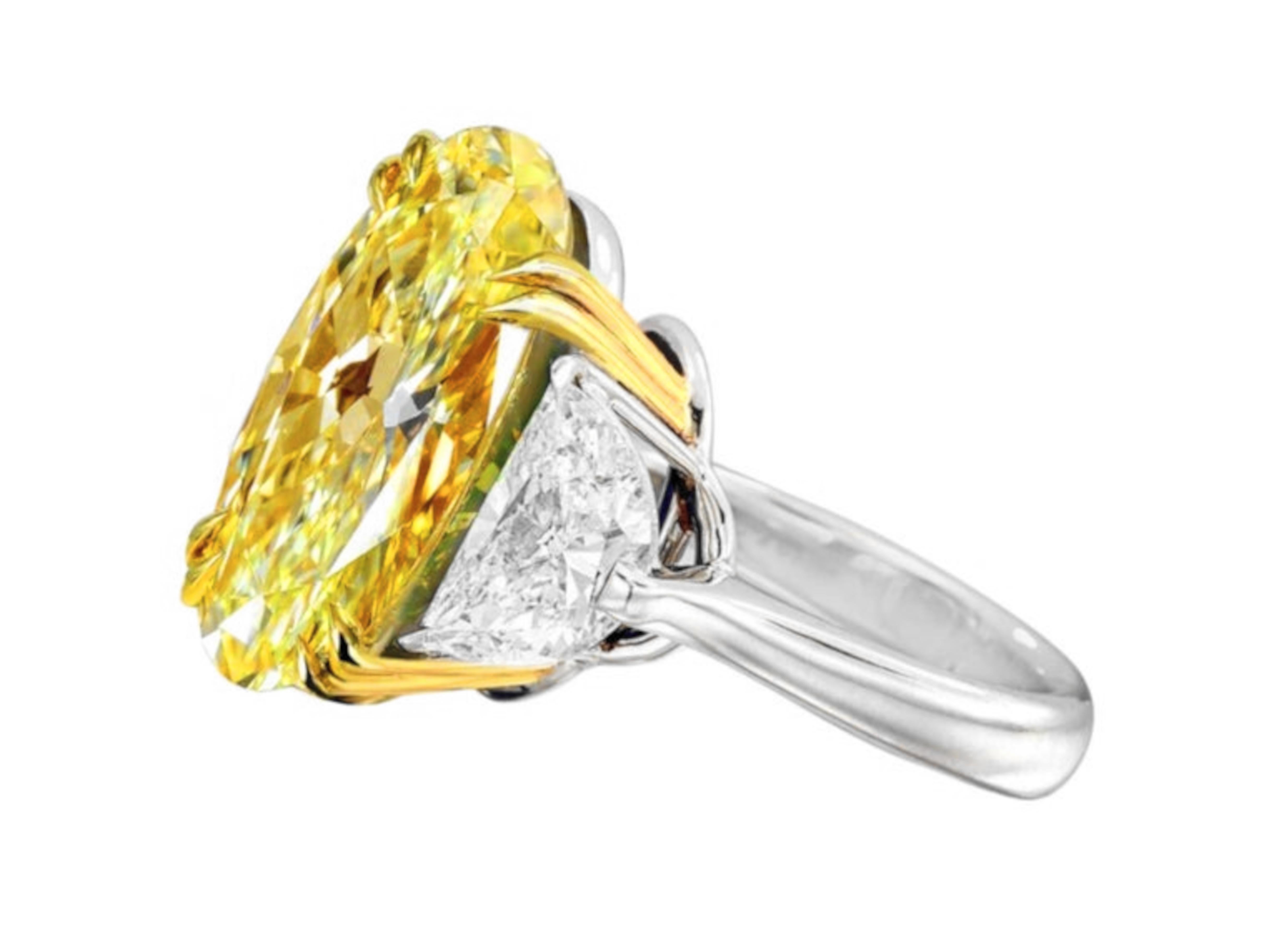an extraordinary ring featuring a stunning 6-carat fancy yellow oval diamond, renowned for its exceptional quality and brilliance. With VVS1 clarity, this remarkable gemstone sparkles with incredible light and offers a beautiful spread, making it a
