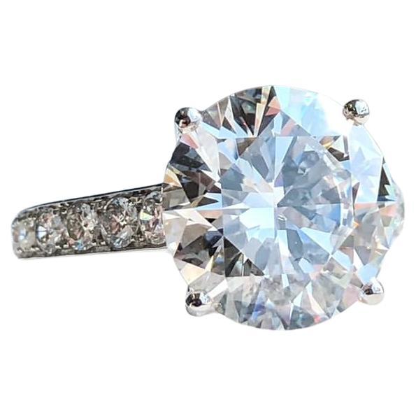 Voici la superbe bague en platine certifiée GIA de 6,10 carats de diamants ronds, ornée de diamants pavés. Au centre de cette magnifique bague éblouit un époustouflant diamant de taille ronde, certifié par le prestigieux Gemological Institute of
