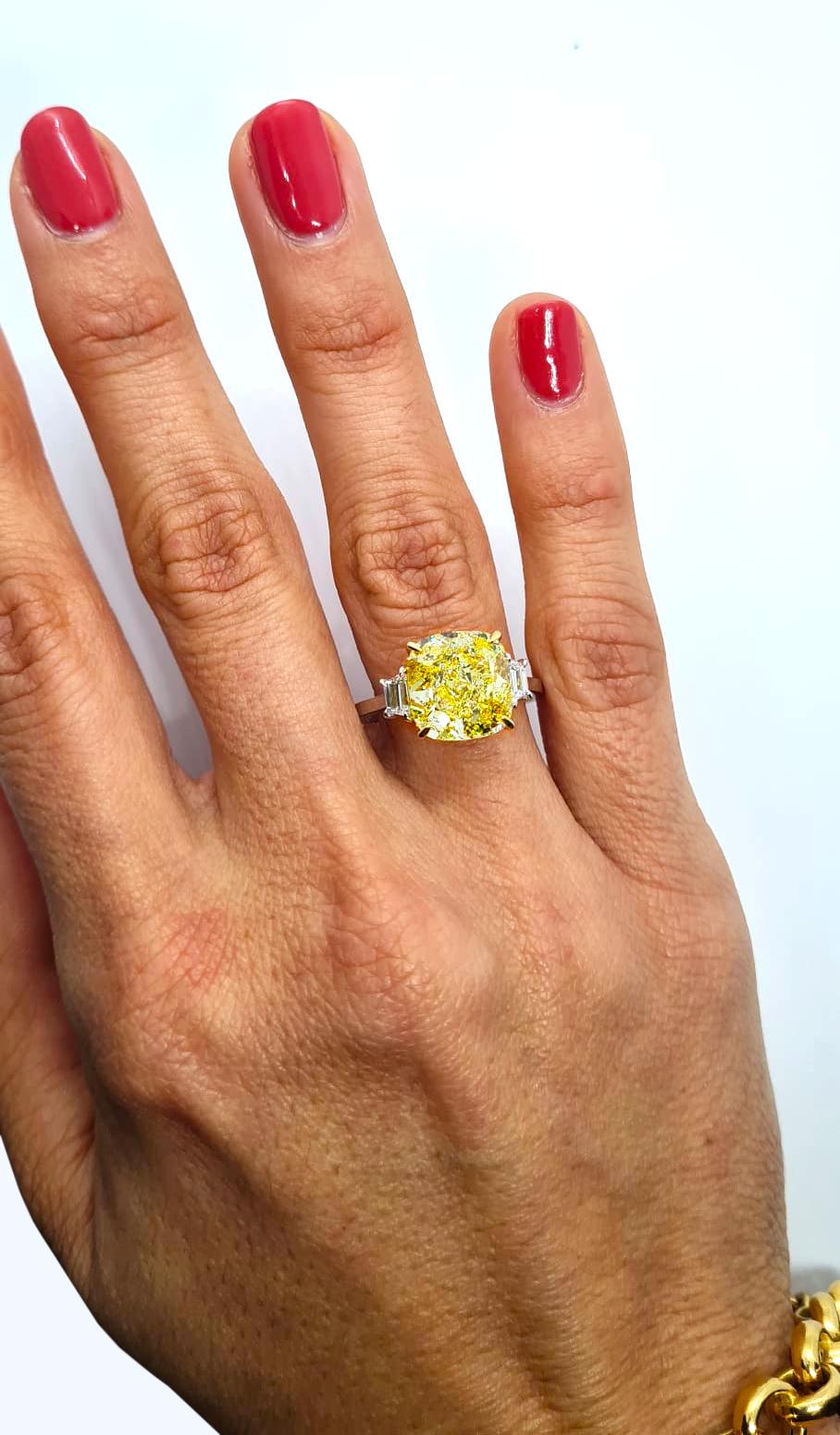 Discover the epitome of elegance and craftsmanship with our magnificent GIA Certified 6.12 Carat Cushion VVS2 Fancy Yellow Diamond Platinum Ring. This exquisite piece is a true testament to timeless luxury and impeccable design.

At the heart of