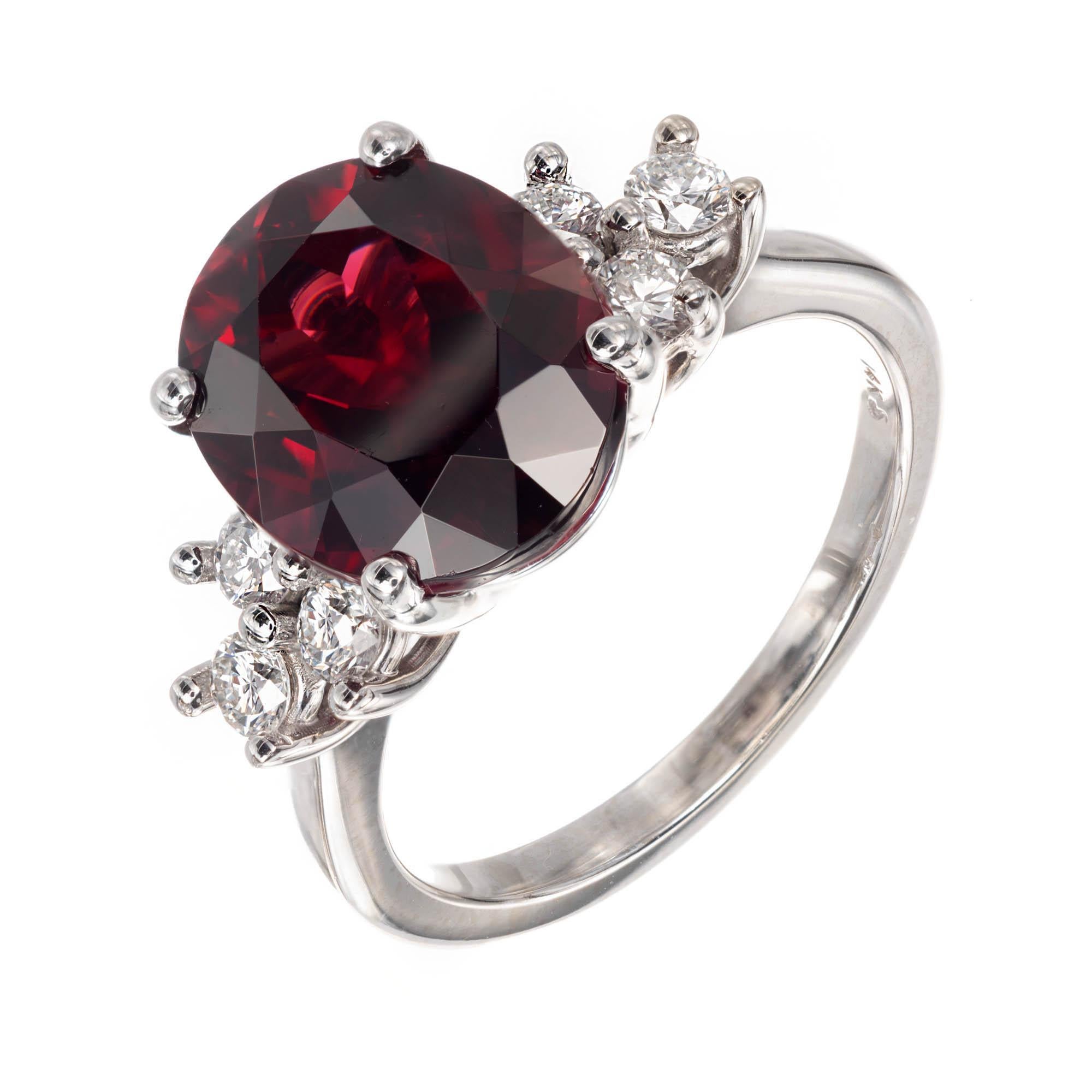 Garnet and Diamond engagement ring with deep red Pyrope Almandine Garnet set in 14k white gold with 3 round brilliant cut Diamonds set on either side.

1 oval Pyrope Almandine deep red Garnet, approx. total weight 6.12cts, 11.99 x 9.87 x 6.78mm, GIA