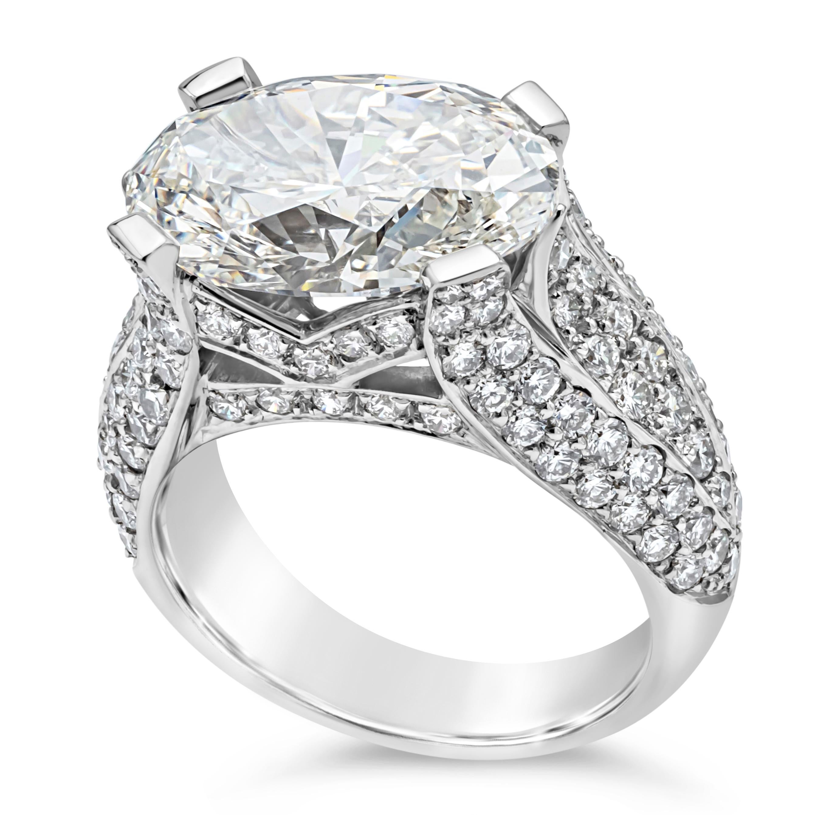 A luxurious and fashionable engagement ring showcasing a 6.16 carat oval cut diamond certified by GIA as I Color, VVS2 in Clarity, set east to west in a four prong platinum setting. Accented and embellished with micro-pave diamonds set half way down