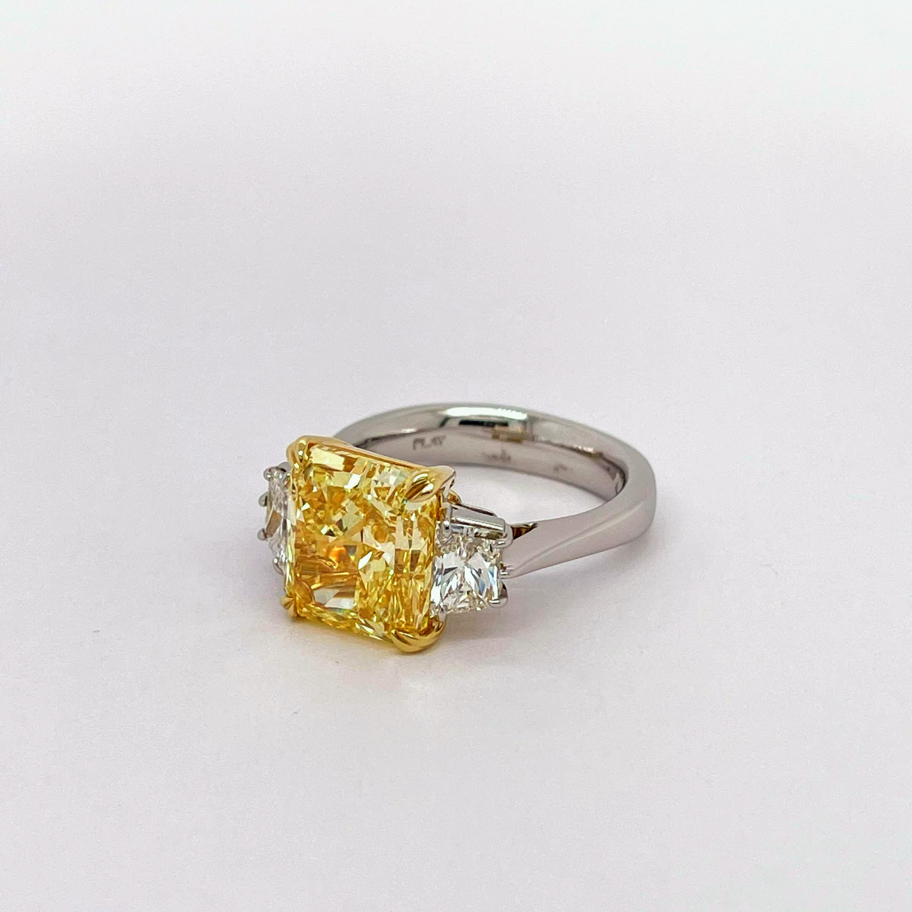 GIA Certified Radiant Shape Cut Diamond 6.17, Fancy Intense Yellow Color VVS1 Clarity together with the 0.94 trapezoids on each side to accentuate the center stone even more. Lays on a beautiful Platinum setting & 18K Yellow Gold basket and prongs