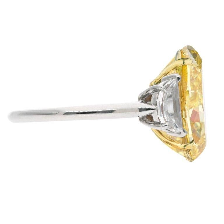5 ct weight radiant cut natural yellow diamond three-stone engagement ring is a stunning piece that combines platinum and 18K yellow gold. The centerpiece is a 5ct natural radiant cut diamond, fancy yellow color which presents a lovely  saturated