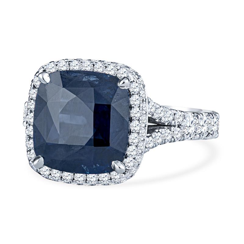 This ring features a beautiful 6.25 carat cushion cut sapphire accented by 1.60 carat total weight in round diamonds. It is set in 18 karat white gold on a split shank. This ring is a size 6.5 but can be resized upon request. 
GIA Report: