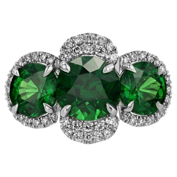 Platinum ring, featuring an untreated 3.08-carat, round Tsavorite Garnet highlighted by two untreated Tsavorite Garnets totaling 3.24 carats, accentuated by 128 round brilliant-cut diamonds totaling 0.94 carats. The center Tsavorite is GIA