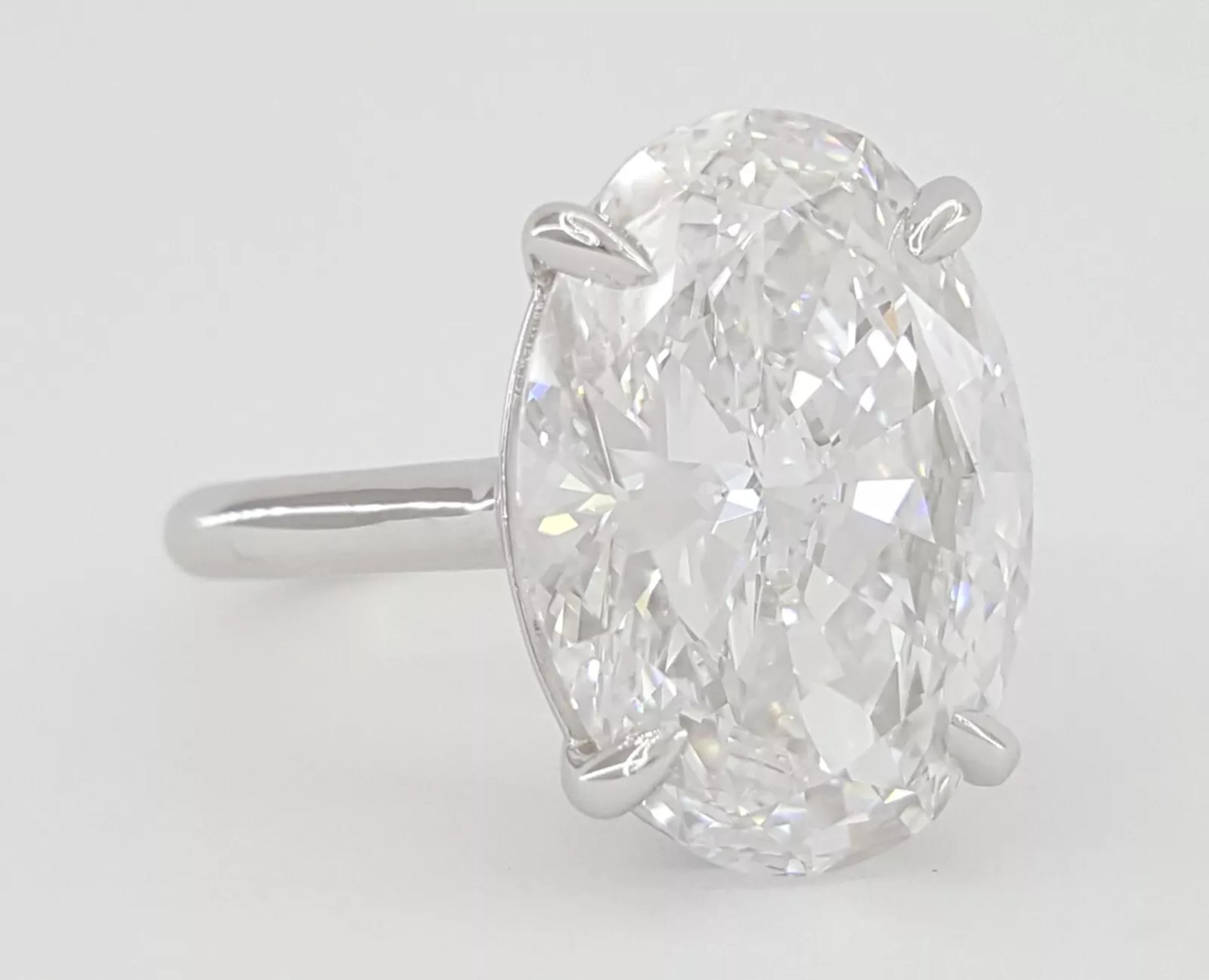 6.04 ct Oval Brilliant Cut Diamond Solitaire Engagement Ring is a stunning piece crafted in platinum. The ring weighs 6.7 grams and is a size 6, featuring a remarkable natural oval brilliant cut diamond at its center.

This diamond weighs 6.04 ct