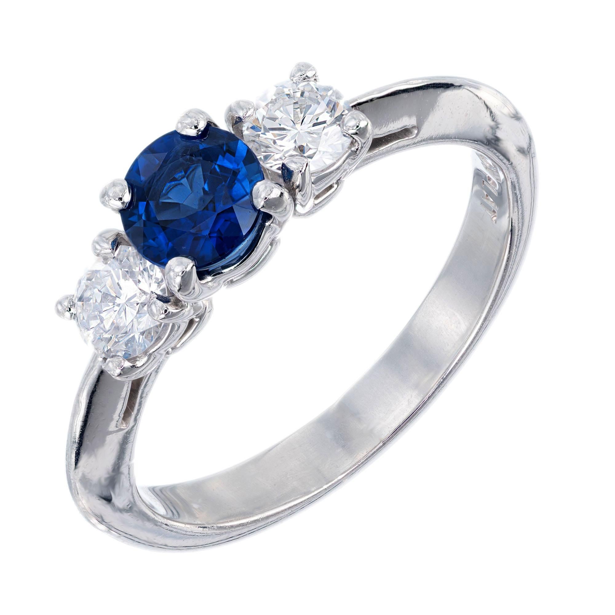 Cornflower blue round sapphire center stone with two round accent diamonds in a platinum three-stone setting. GIA certified center stone. 

1 round cornflower blue Sapphire, approx. total weight .65cts, SI1, 4.90 x 4.80 x 3mm, CMT Type 1, simple