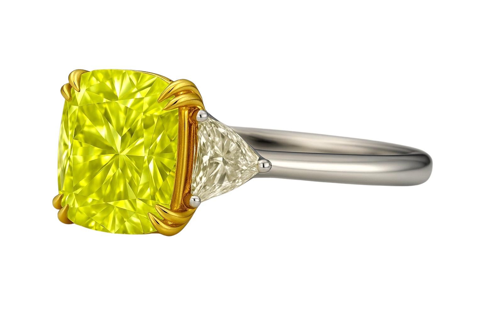 Cette bague à trois pierres est centrée sur un diamant coussin certifié GIA de 6,51 carats de taille brillante modifiée, de couleur jaune fantaisie et de pureté VS1, qui présente une brillance et une saturation de couleur exceptionnelles. Le diamant