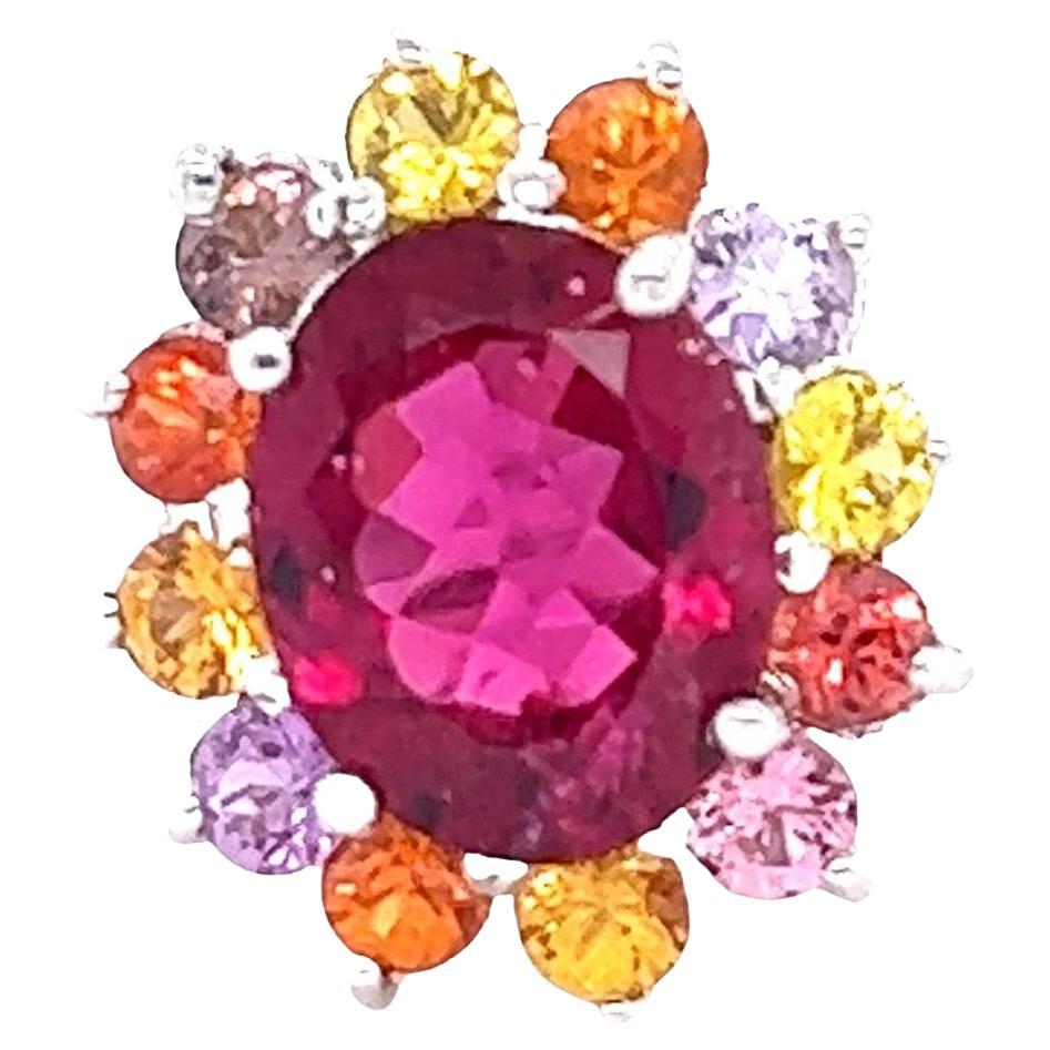 Anello Cocktail in oro bianco con zaffiro rubellite naturale certificato GIA da 6,53 carati

Questo anello ha una tormalina rosa caldo (rubellite) dal taglio ovale di 4,23 carati ed è elegantemente circondato da 12 zaffiri multicolore dal taglio