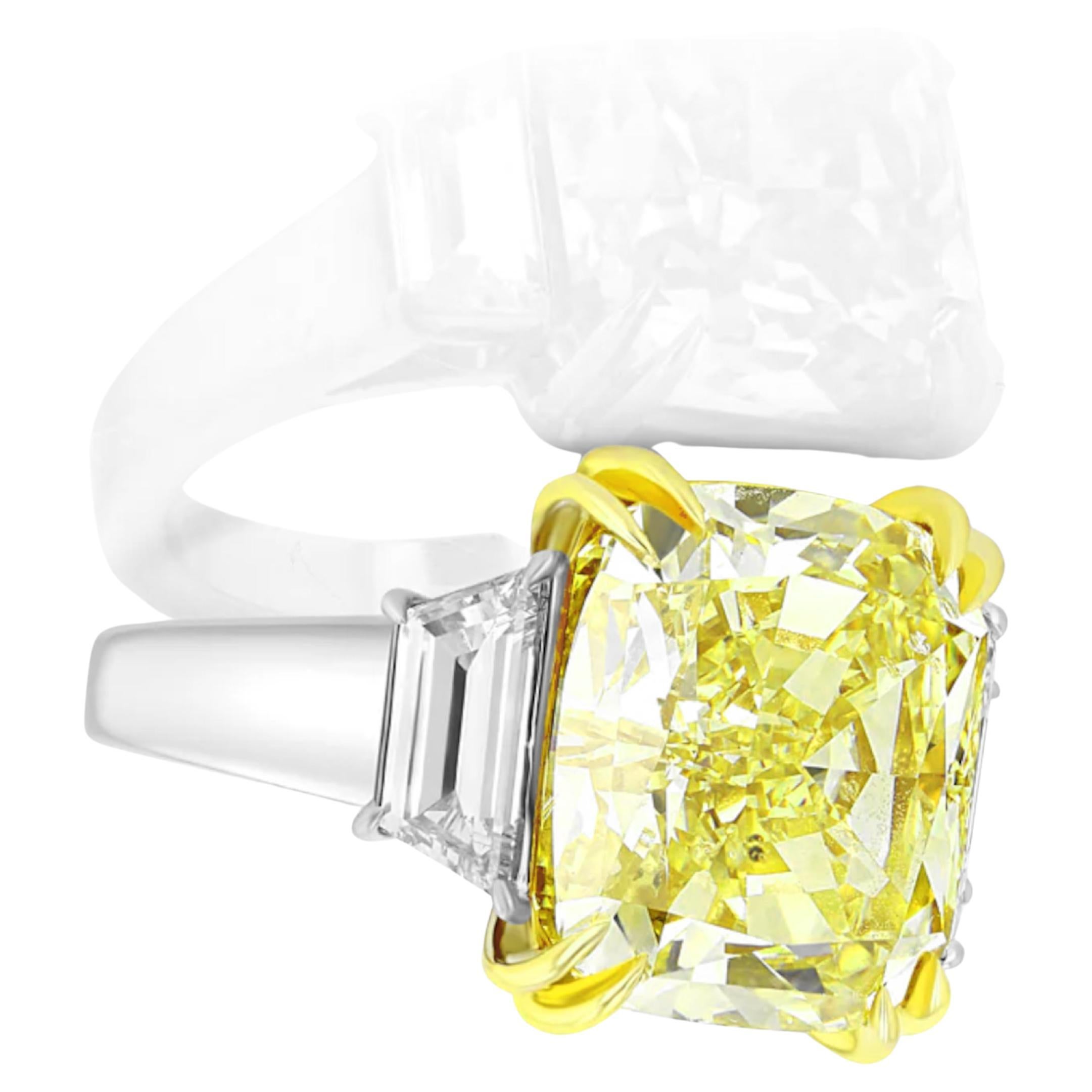  stunning Fancy Yellow Cushion Cut Diamond, weighing an impressive 6.53 ct. This exceptional diamond features a VVS2 clarity, ensuring brilliance and fire that captures the eye. Set in a luxurious platinum band, the ring is complemented by two
