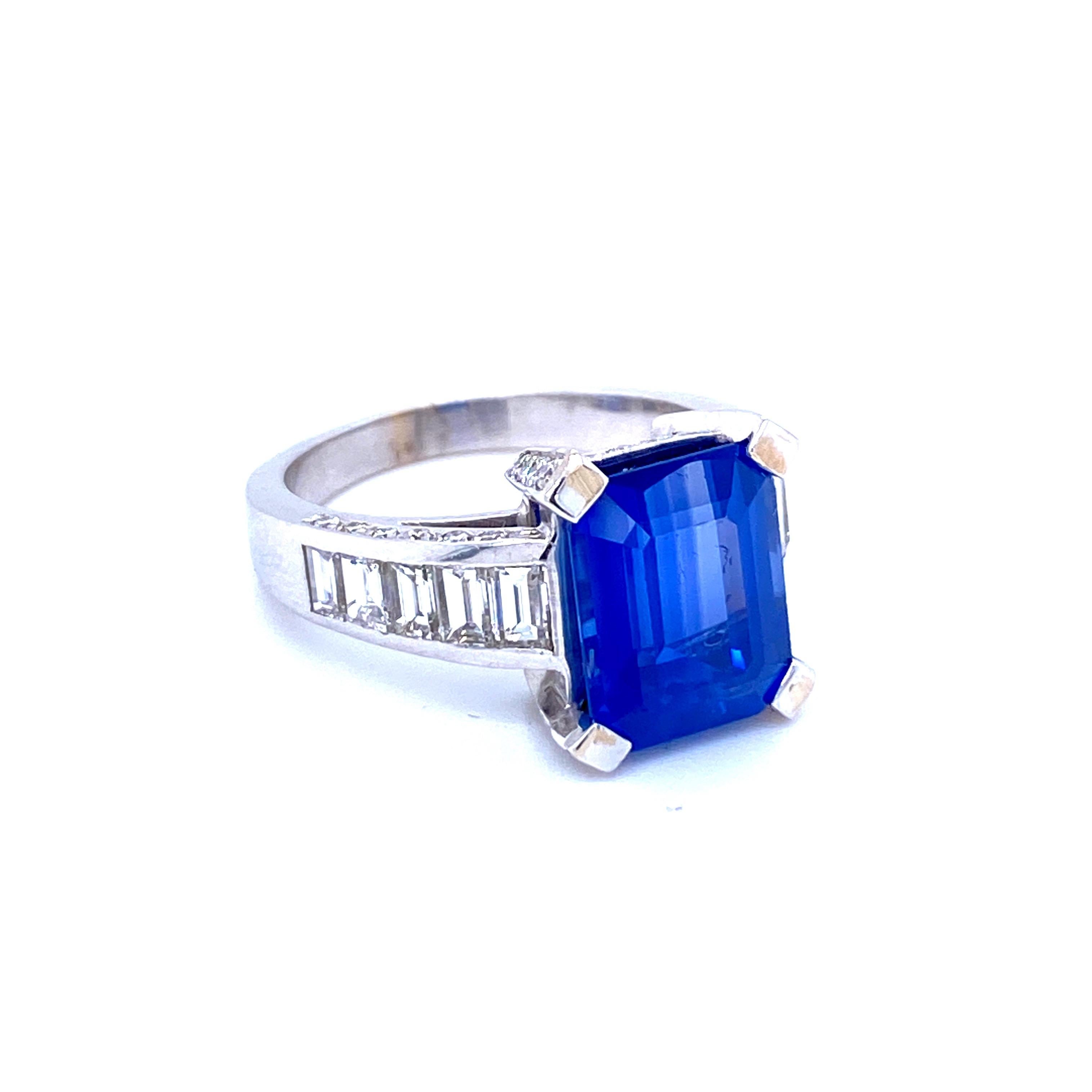 This beautiful Sapphire and Diamond Art Deco style Ring is crafted in solid 18k white gold and it weighs approx. 8.60 grams.
A stunning, royal blue mixed-cut Ceylon Sapphire weighing 6.59 carats,  flanked by 10 baguette cut diamonds and 42 round