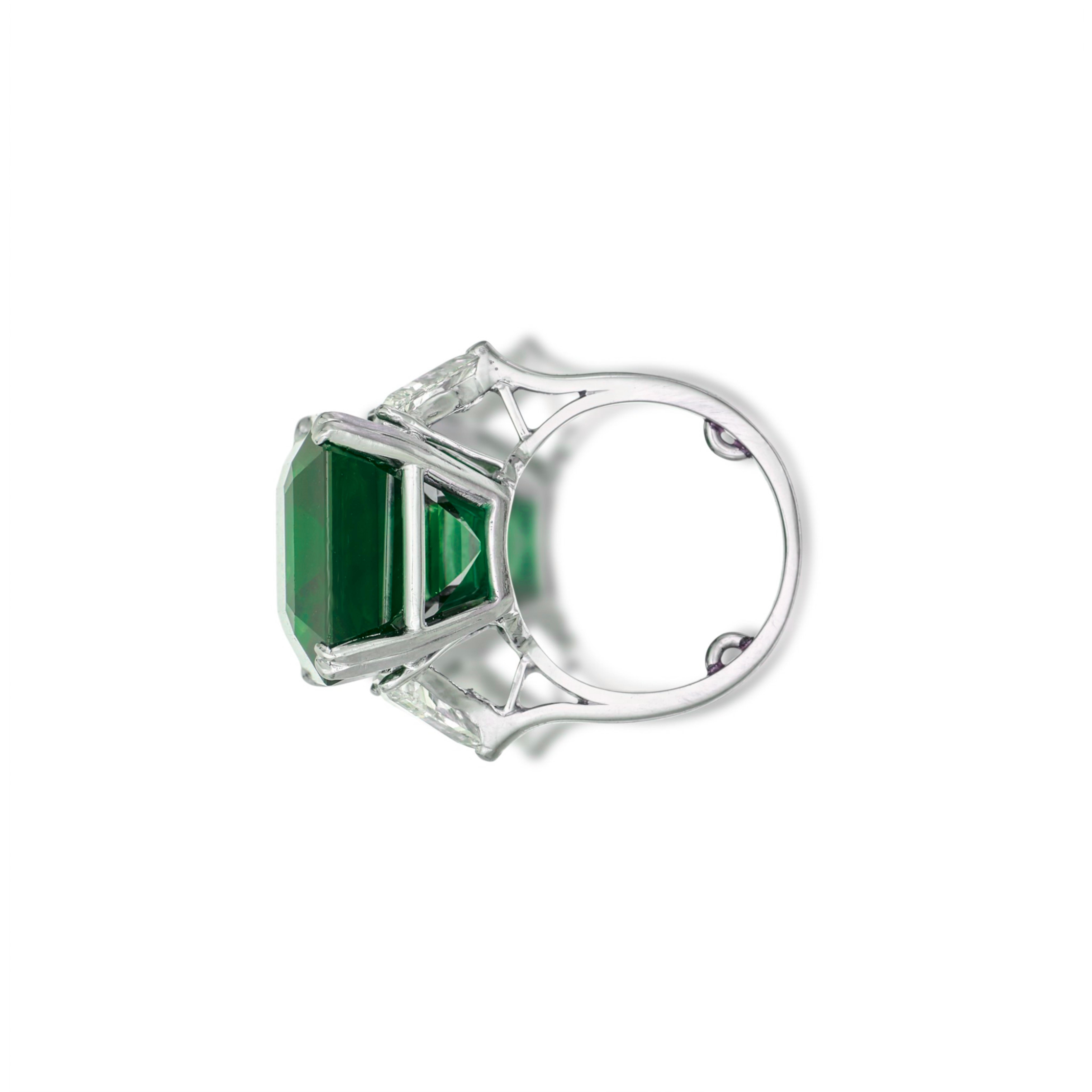 Indulge in timeless elegance with this breathtaking ring, featuring a substantial 6.68 carat emerald-cut vivid green, certified by GIA. 

Accompained by a dazzling pair of trillion cut diamonds, this masterpiece is mounted in platinum for a