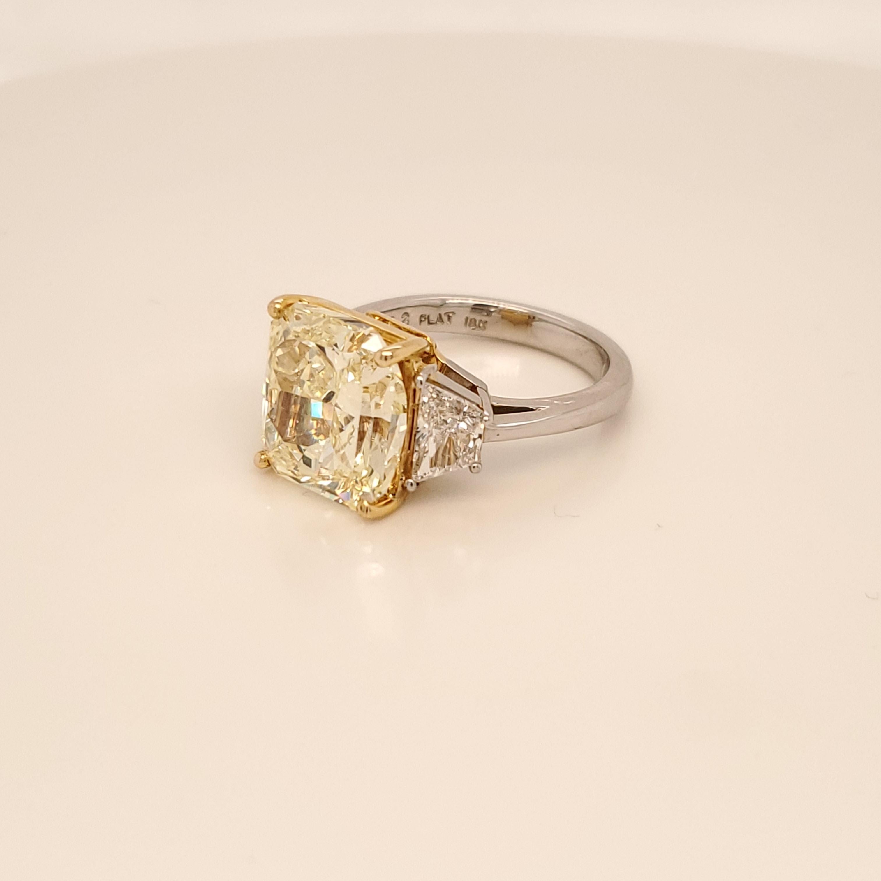 Here we have an extremely hard to find Radiant Cut 6.69 carats Fancy Yellow in color and Internally Flawless in clarity GIA certified. Set in a Platinum and 18 Karat yellow Gold ring with two trapezoid shaped diamonds as side stones weighing 0.92