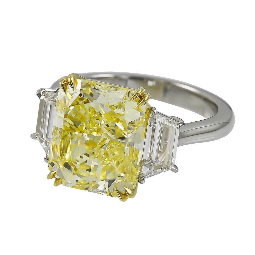 Magnificent engagement ring from ISSAC NUSSBAUM NEW YORK.
This beautiful elongated Radiant cut fancy yellow diamond is flanked by two colorless stones.

The Magic is in the cut!
This stone is special and rare given that its Elongated radiant cut.