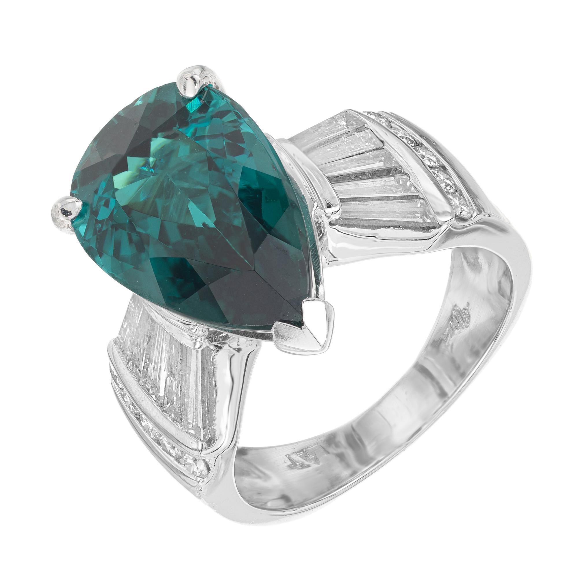 Rare, rich GIA certified blue green tourmaline and diamond cocktail ring. Mounted in a platinum setting and accented with round and tapered baguette diamonds. This ring boasts a stunning pear-shaped 6.74cts tourmaline pear shaped gemstone accented