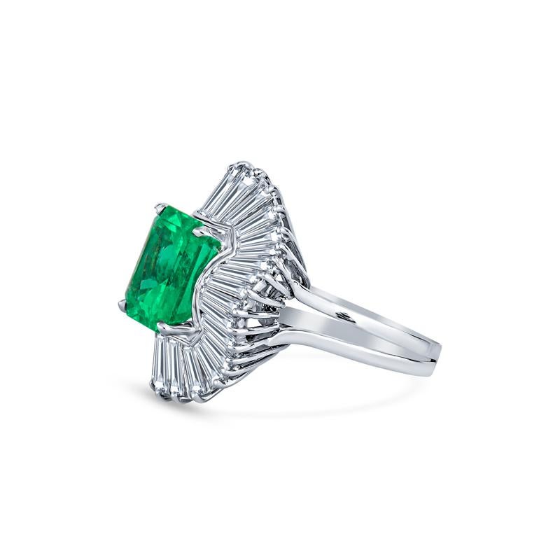 This exquisite ring features a captivating 6.77ct emerald cut Colombian emerald paired with 34 sparkling tapered baguette diamond accents totaling approximately 6.4ctw. Crafted in luxurious platinum, it's an elegant piece designed for the discerning