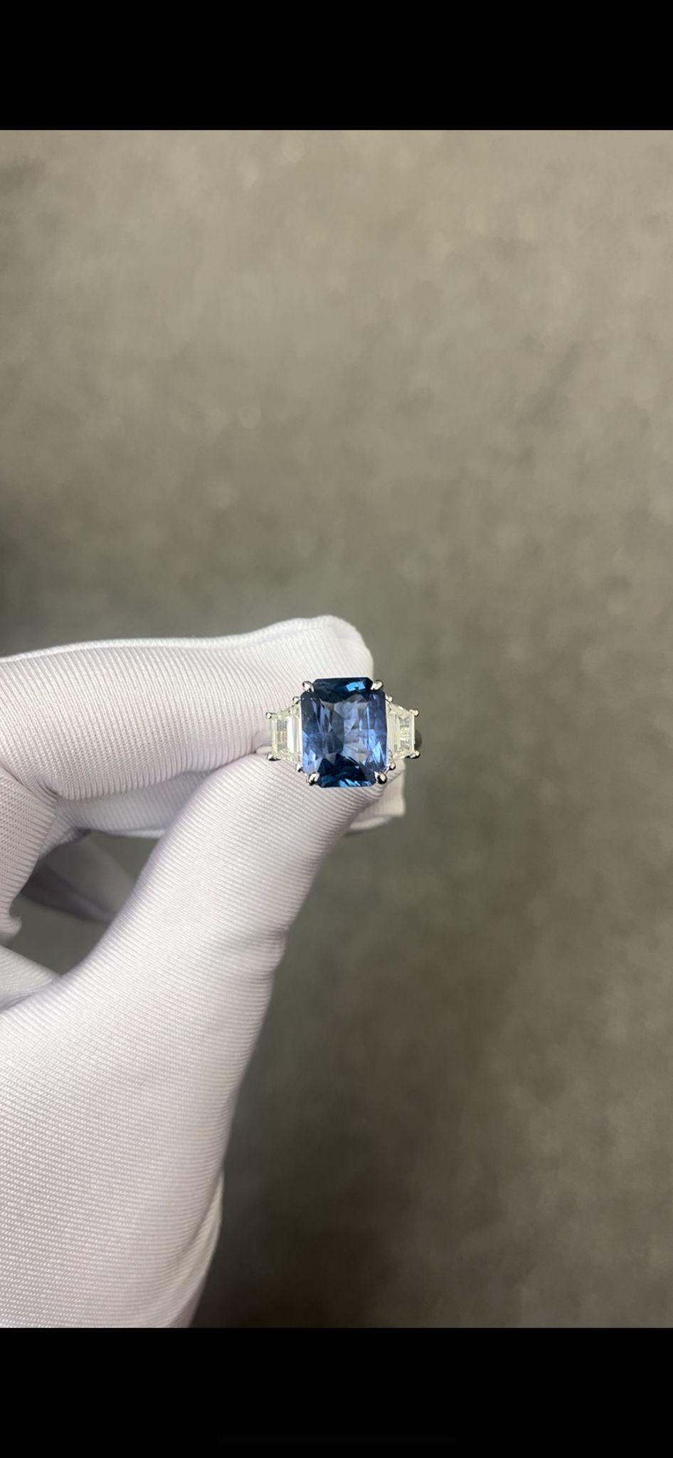 GIA certified Radiant Cut Sapphire weighing 6.84 carats
Measuring (12.26x9.58x5.87) mm
Two Trapezoid diamonds weighing .80 carats total
Set in platinum ring