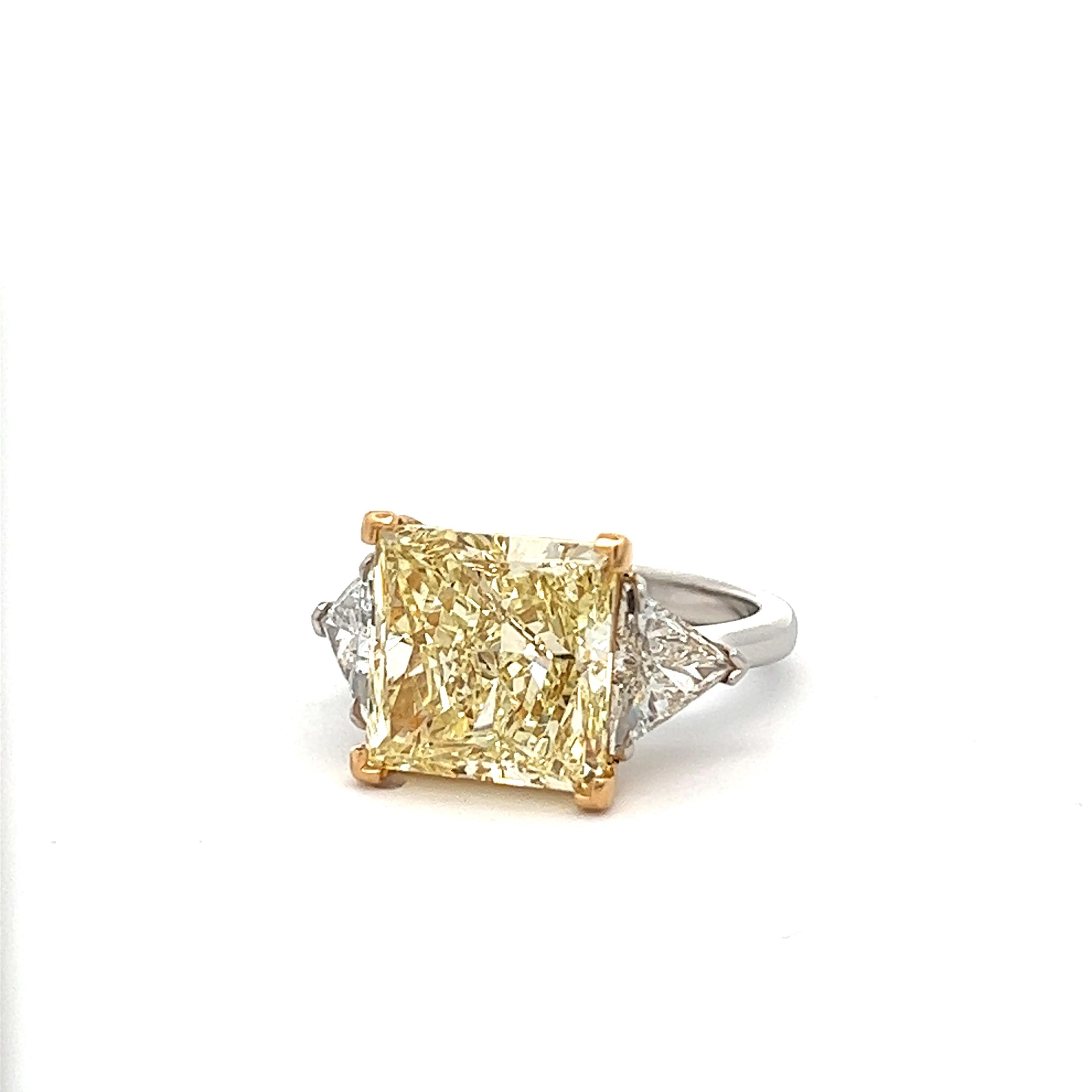 6.91 carat Princess Cut, Natural Fancy Light Yellow VS2 Clarity,  with two 1.15 CT F Colors VS2-SI1 Clarity is accompanied by a GIA certificate. This incredible bright cushion is full of life and set in a handmade 18K White & Yellow gold setting,