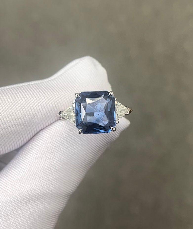 GIA Certified Radiant Cut Ceylon Sapphire weighing 6.96 carats
Measuring (11.35x10.72x5.76) mm
Triangle Diamonds weighing .56 carats
Set in platinum