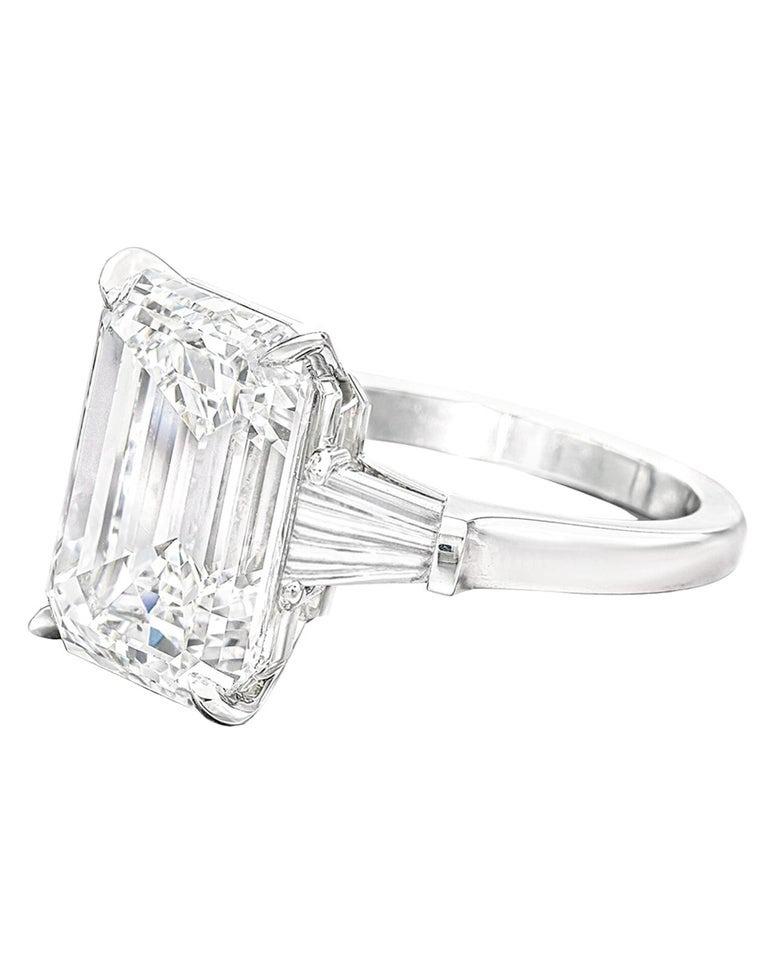 This extraordinary cocktail ring features a breathtaking GIA-certified 7 carat emerald cut diamond, set in a timeless platinum mounting flanked by two elegant tapered baguette side stones. The center stone boasts an exceptional E color and VS1