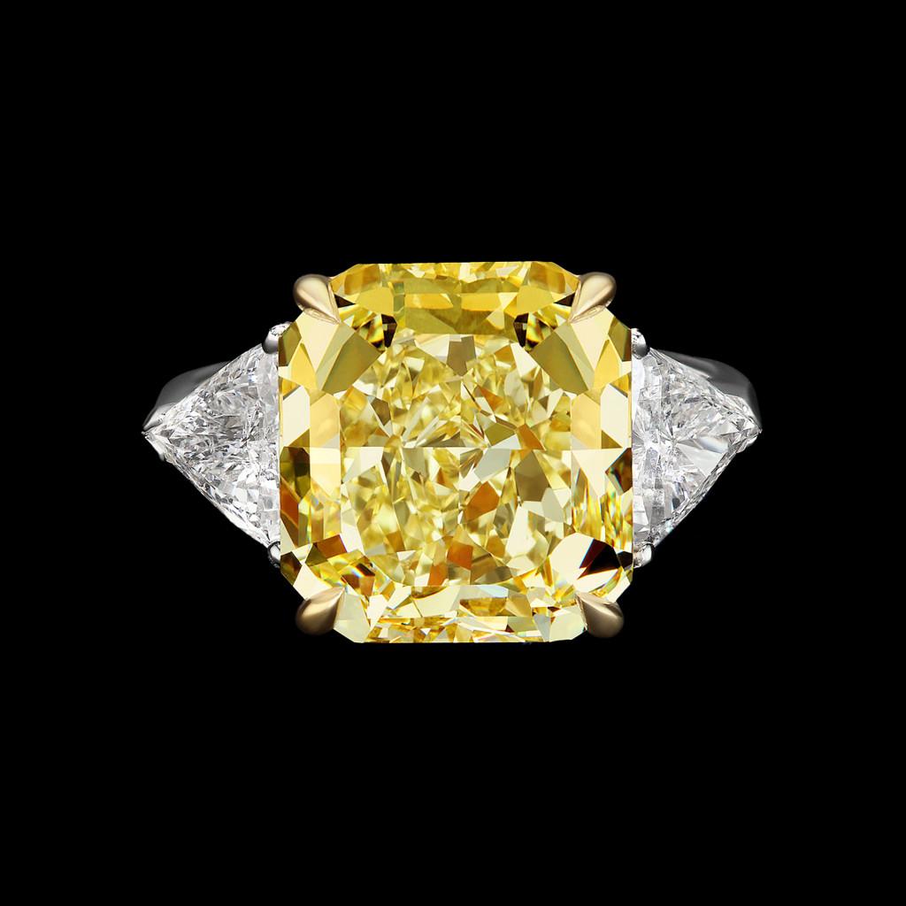 This stunning engagement ring boasts a magnificent centerpiece: a GIA certified 7 carat fancy intense yellow diamond solitaire. The diamond's fancy yellow color grade radiates a captivating and vibrant hue, imbuing the ring with a sense of