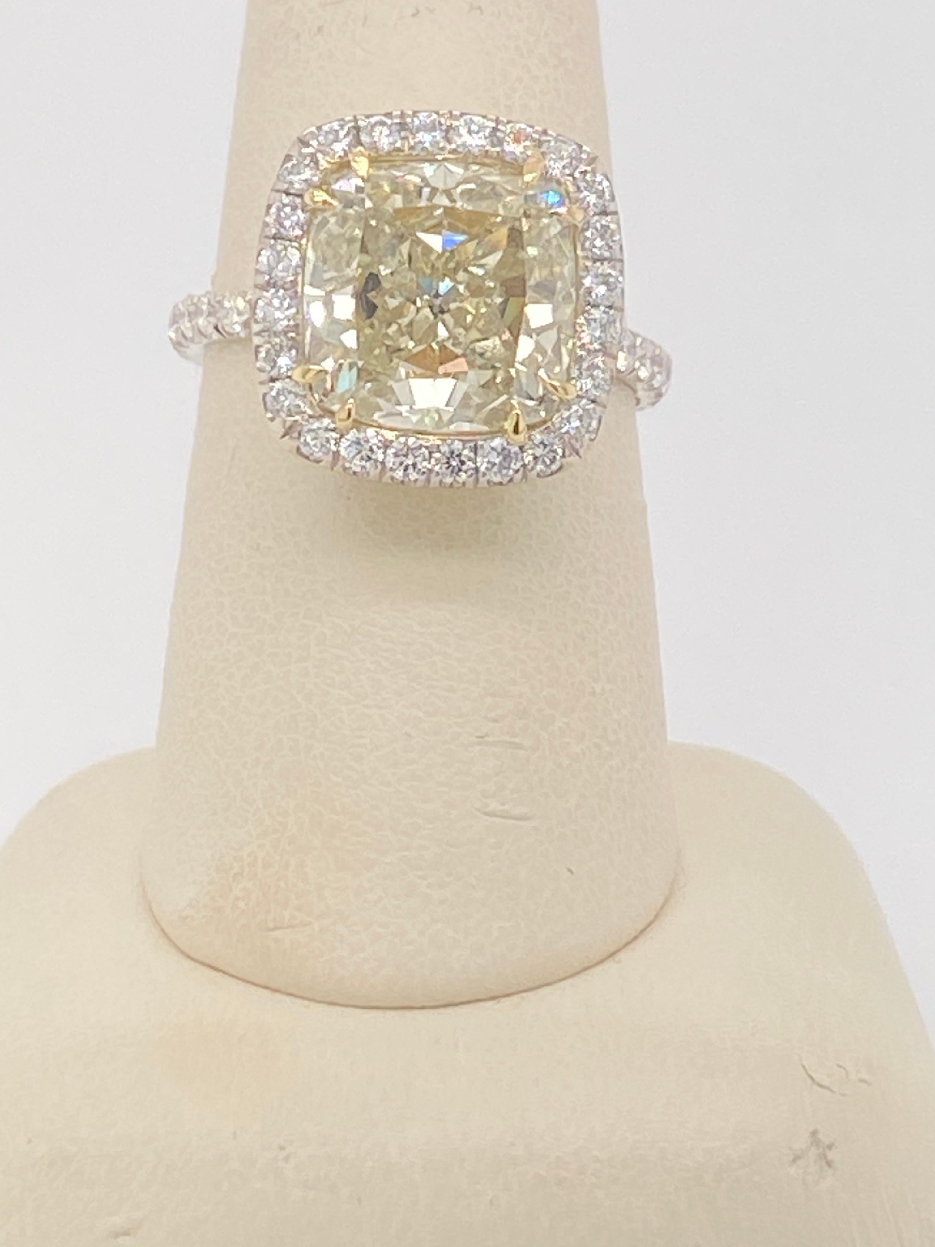Show Stopping RING FOR SURE!  This 7.01 Cushion cut yellow diamond is set in 18k white gold and features a white diamond halo as well as diamonds down the sides of the shank.  This ring is sure to get her to say yes and sure to make your day