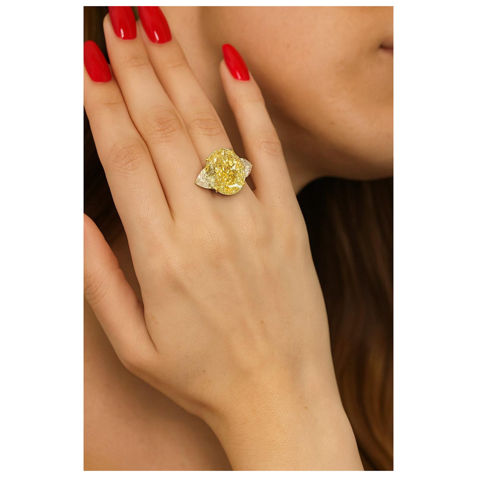 GIA Certified 7.01 Carat Fancy Yellow Oval Diamond Ring in 18K Yellow Gold and Platinum with Trillion Side Stones

At the heart of this extraordinary creation lies a GIA certified 7.01 carat Fancy Yellow oval modified brilliant diamond, boasting an
