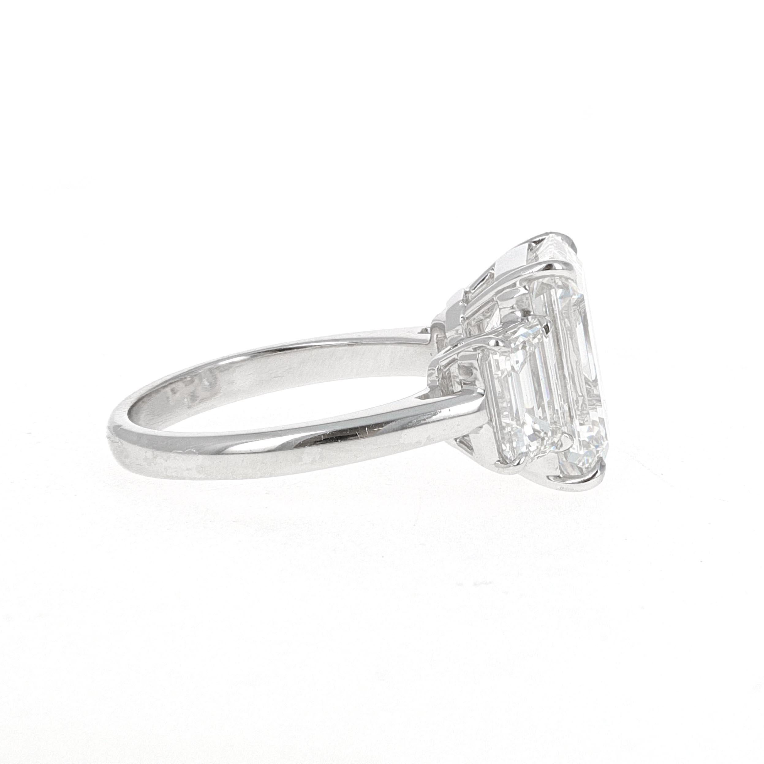 Stunning hand made  platinum, GIA Certified, 7.14 carat total weight three-stone emerald cut diamond ring. The center stone weighs 5.26 carats and is an F-VS1 and emerald cut diamond. The center stone measures 12.03 x 8.25 x 5.60 mm.
The side stones