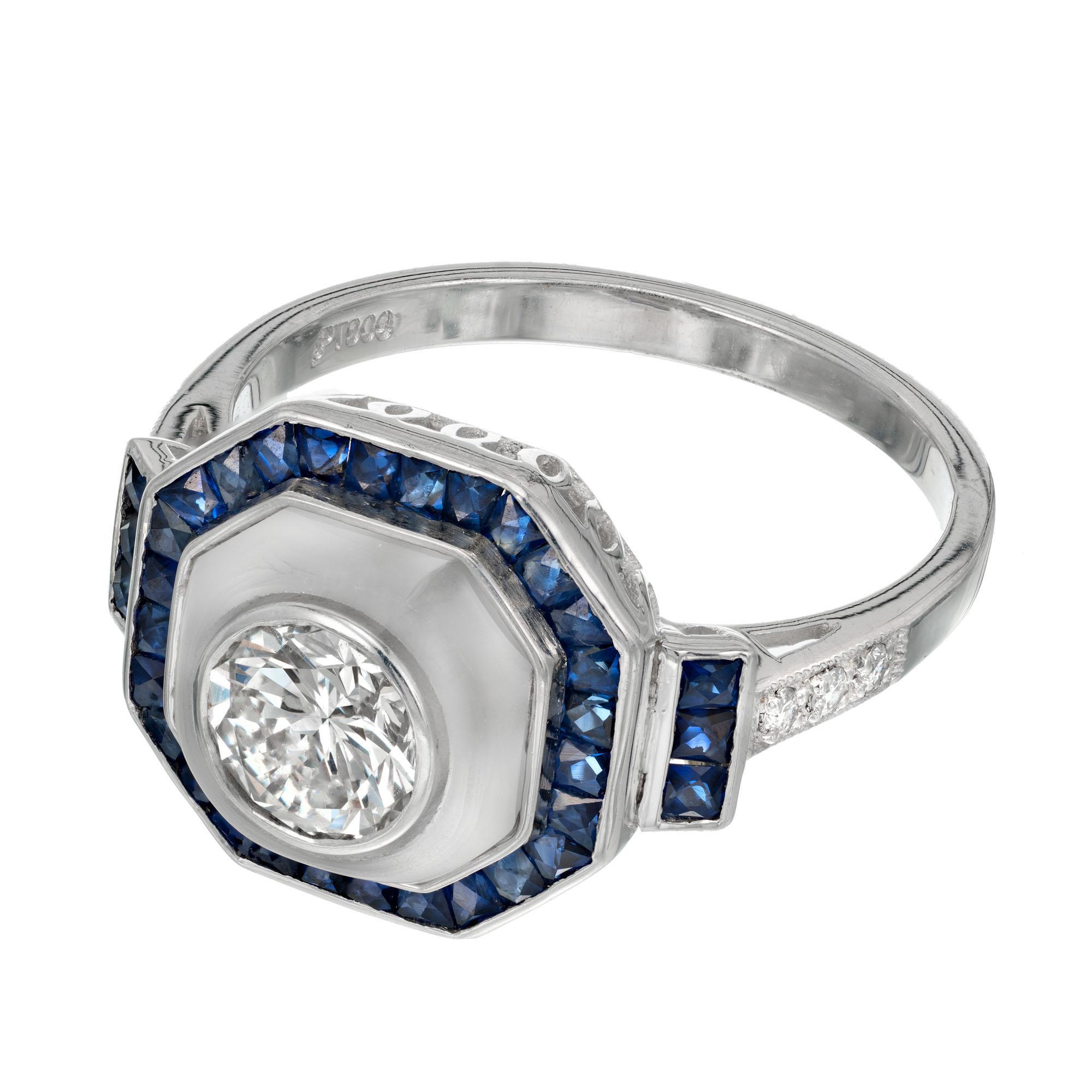 Round diamond and calibre hand cut sapphire halo engagement ring. GIA certified center diamond with Angel skin quartz center and a halo of calibre cut square sapphires in a platinum setting with diamonds along both sides of the shank. Created in the