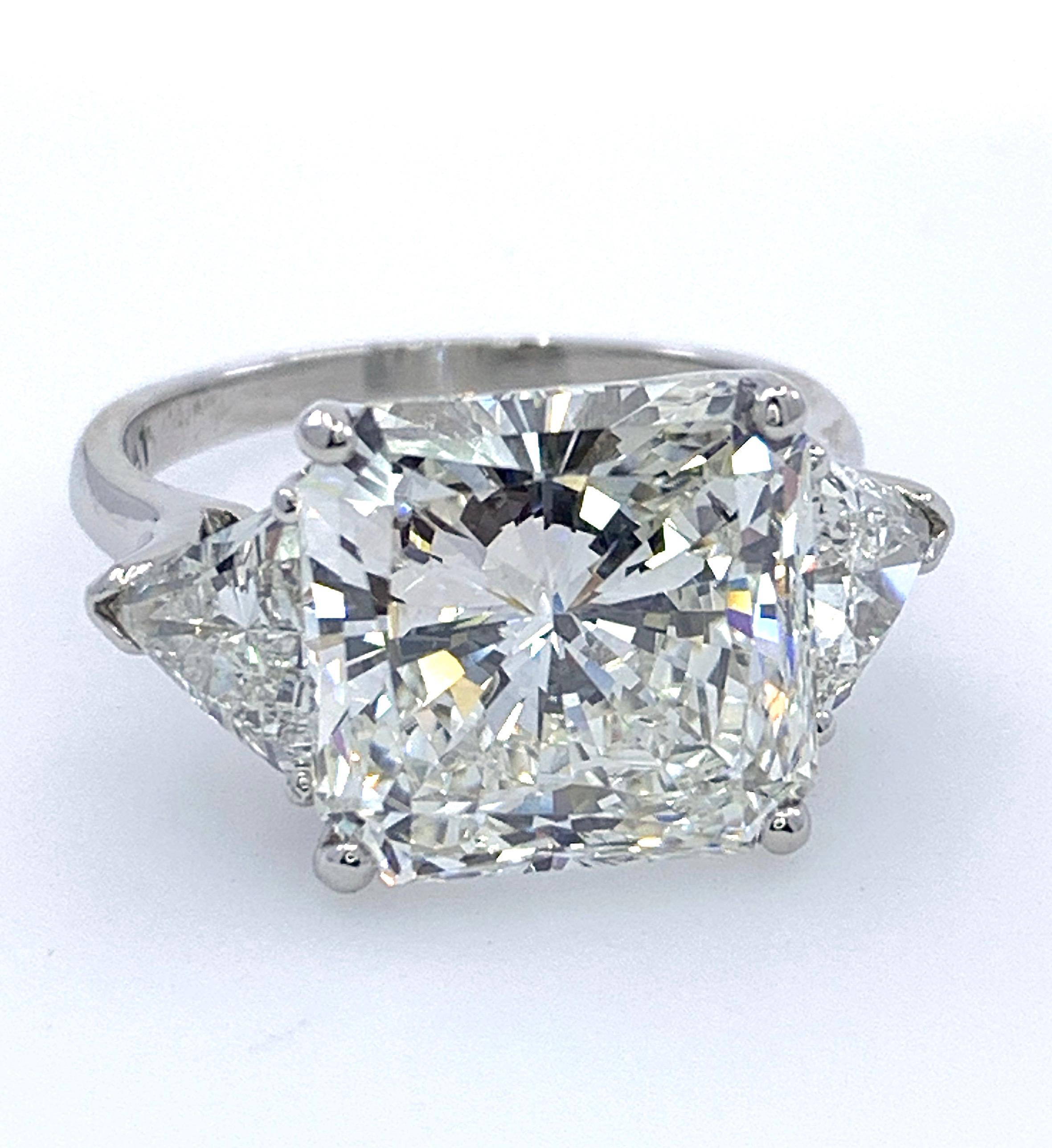 This important ring, made in 2009,  features a very slightly elongated, cut-cornered square (i.e., Radiant) diamond prong-set between two trillions in a handmade platinum mounting. 

The center stone comes with a GIA certificate (#6204534748) rating