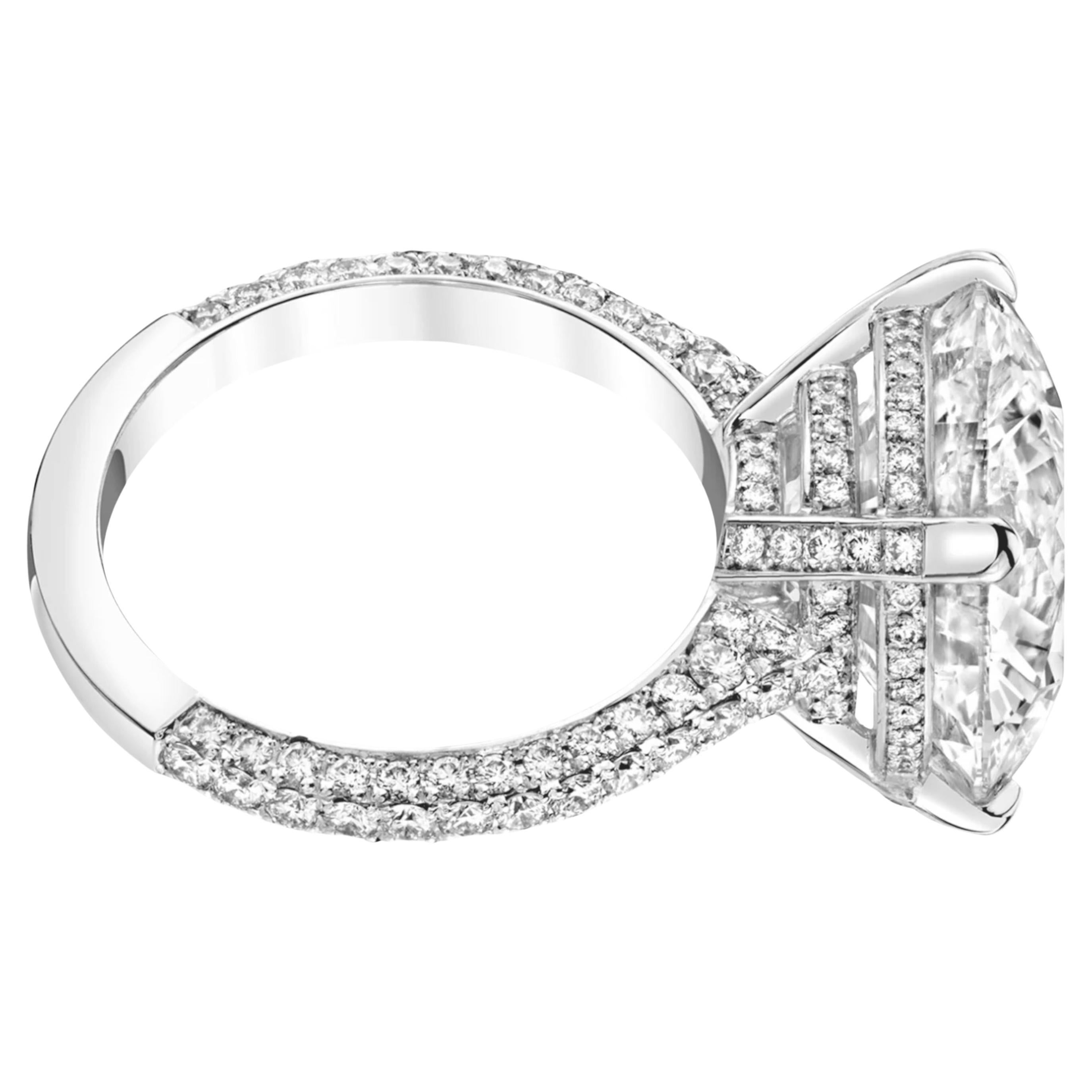 This stunning GIA certified ring features a remarkable 7.33 carat round cut diamond as it's centerpiece, enveloped in an elegant pavé setting that enhances it's brilliance. 
Crafted in 18K white gold, the ring’s design exudes sophistication and