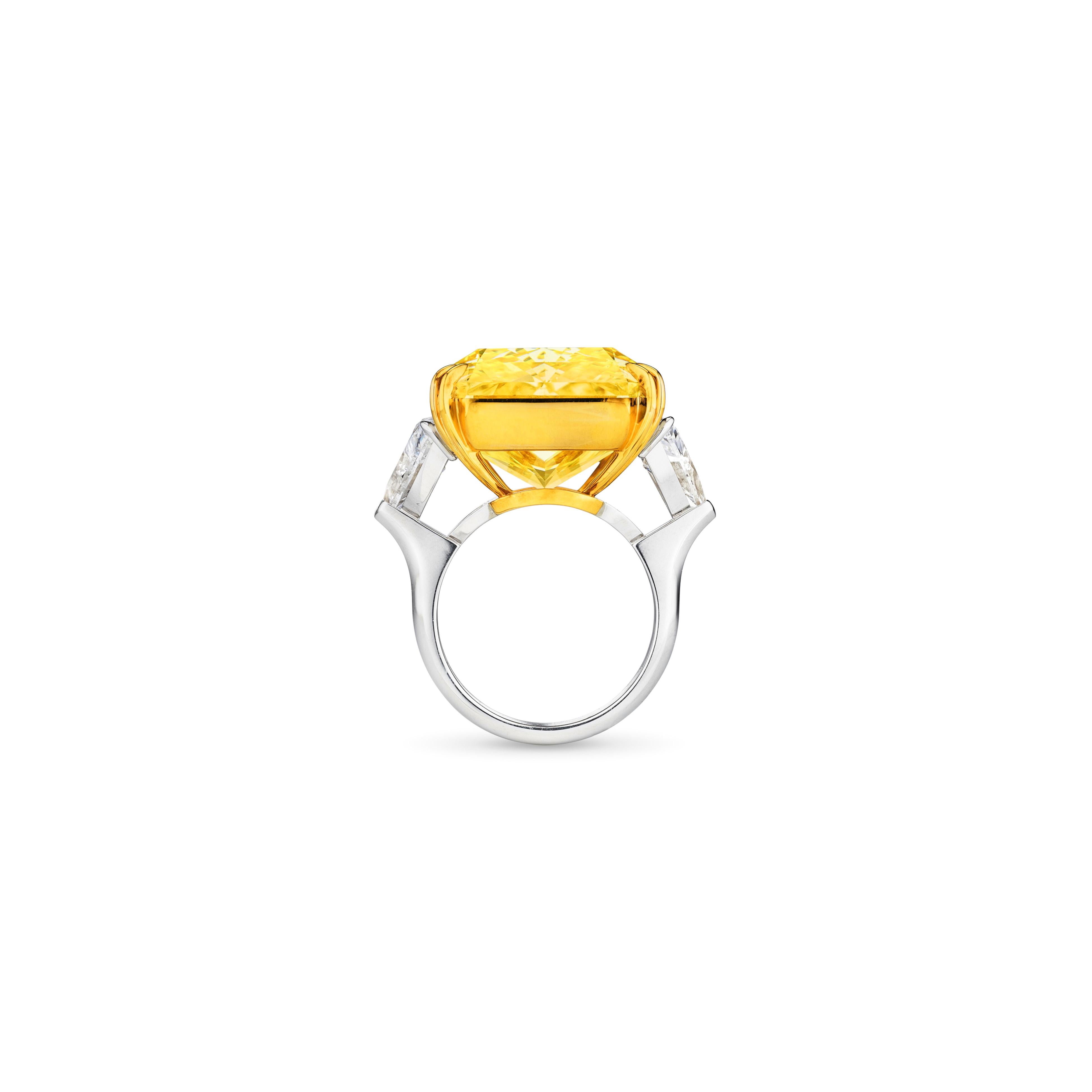 La bague de fiançailles à trois pierres en diamant jaune fantaisie naturel de 7,40 ct de poids total est une pièce étonnante qui combine le platine et l'or jaune 18 carats. La pièce maîtresse est un .40  ct diamant de taille radieuse, de couleur