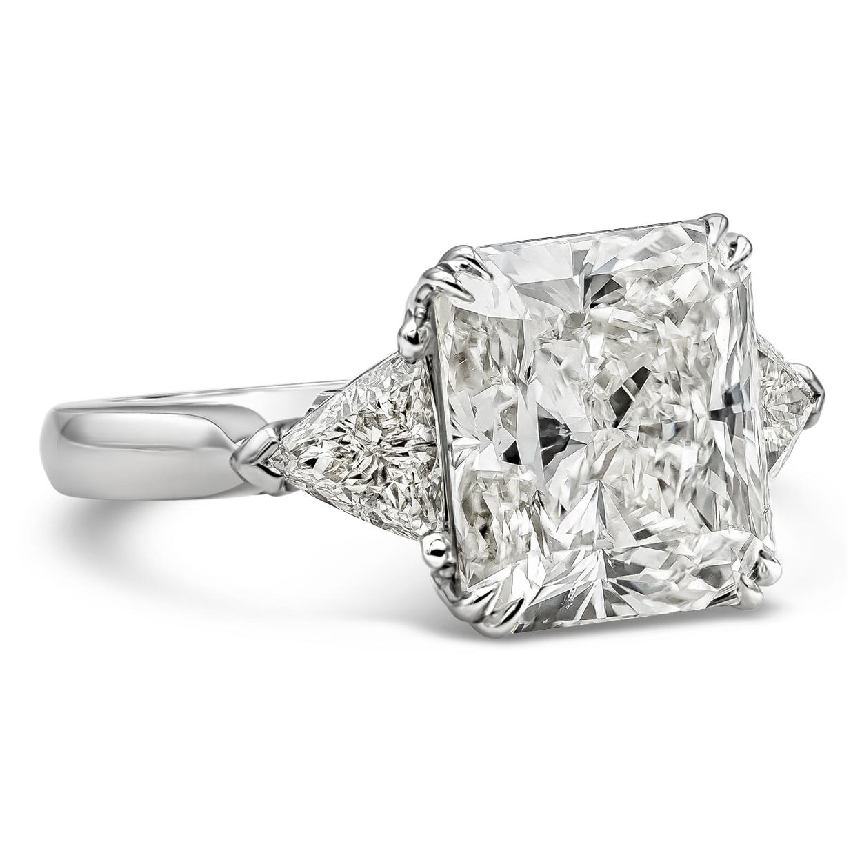 A sophisticated three stone engagement ring showcasing a GIA certified 7.41 carats radiant cut diamond, M Color and SI1 in clarity, set in a timeless eight prong setting. Flanked on each side by brilliant trillion cut diamonds weighing 0.75 carats