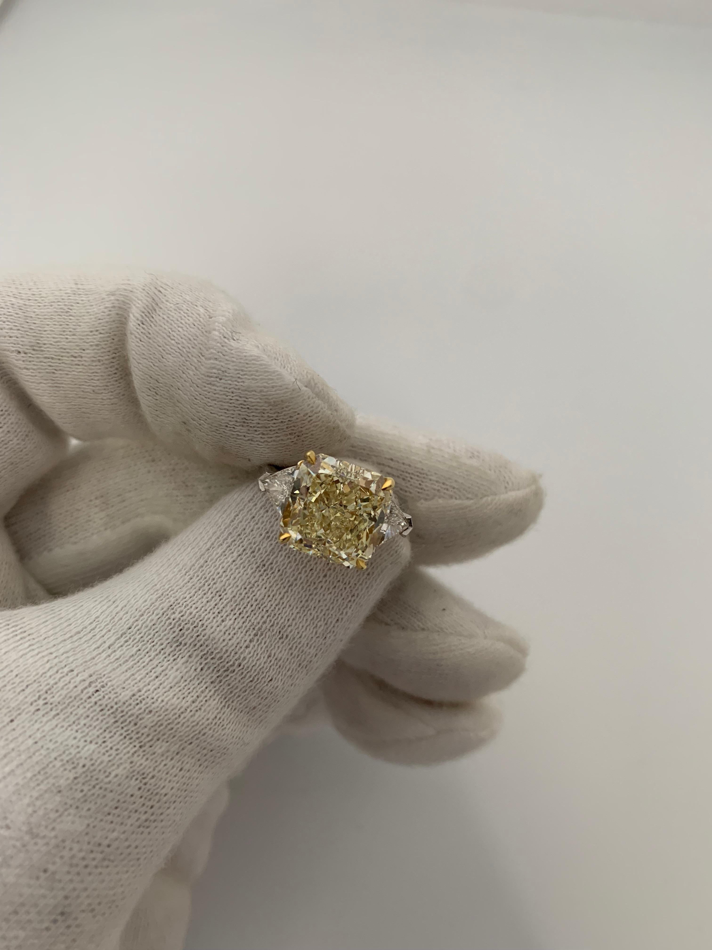 Centered upon a beautiful Fancy Light Yellow Diamond with a VS1 Clarity. Square and Bold Radiant Cut flanked by 2 Triangle Diamonds weighing 0.82 Carats.
Set in Platinum and 18 Karat Yellow Gold.