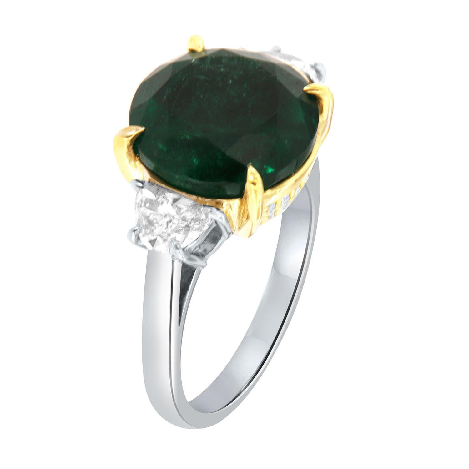 This Stunning Platinum and 18k Yellow Gold ring features a Rare 7.47 Carat Round-shaped Vibrant deep green Natural Emerald flanked by two(2) Half-Moon shaped diamonds in a total weight of 0.70 Carat. A total of thirty (30) Brilliant round diamonds