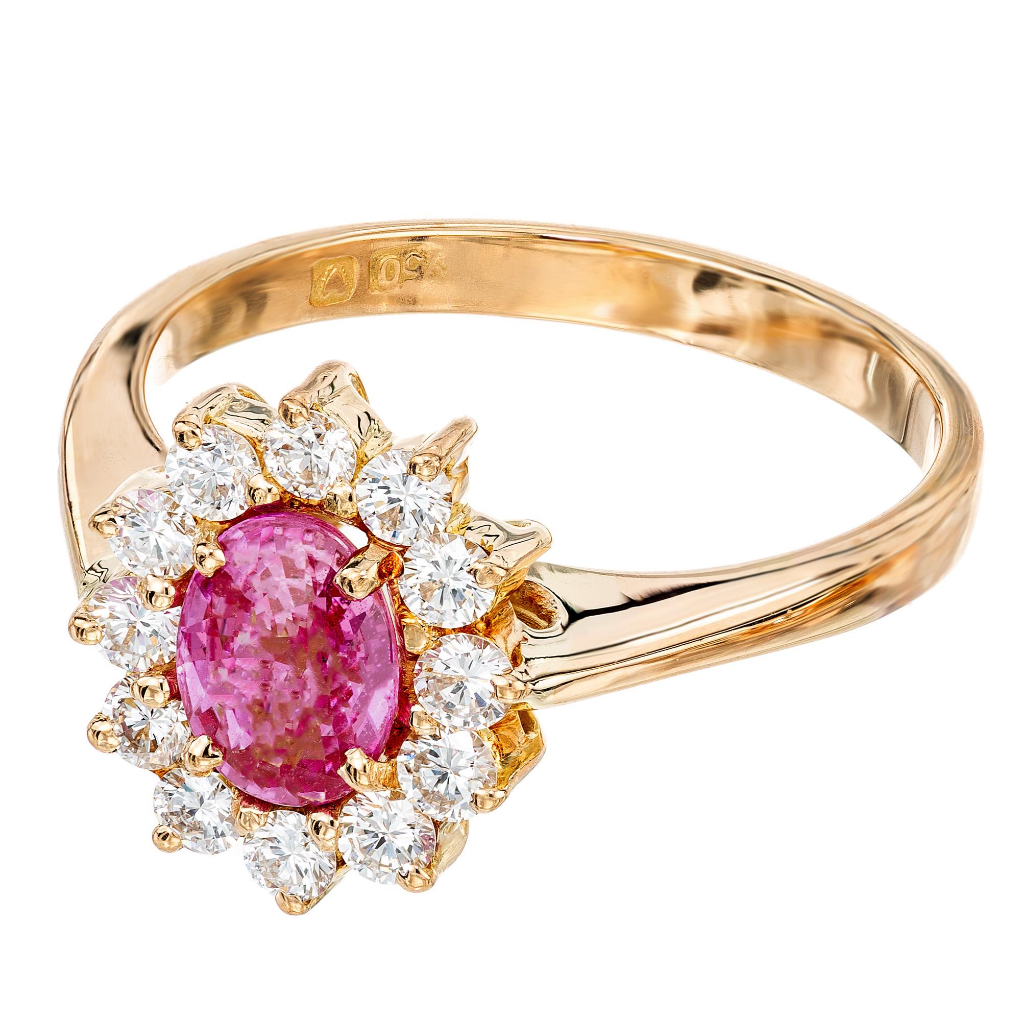 Anillo de compromiso de zafiro y diamantes de los años 80. Engastado con un deslumbrante zafiro rosa ovalado de 0,75 ct certificado por el GIA. Montada en un engaste de oro amarillo de 18 quilates con un halo de 12 diamantes de talla redonda. El